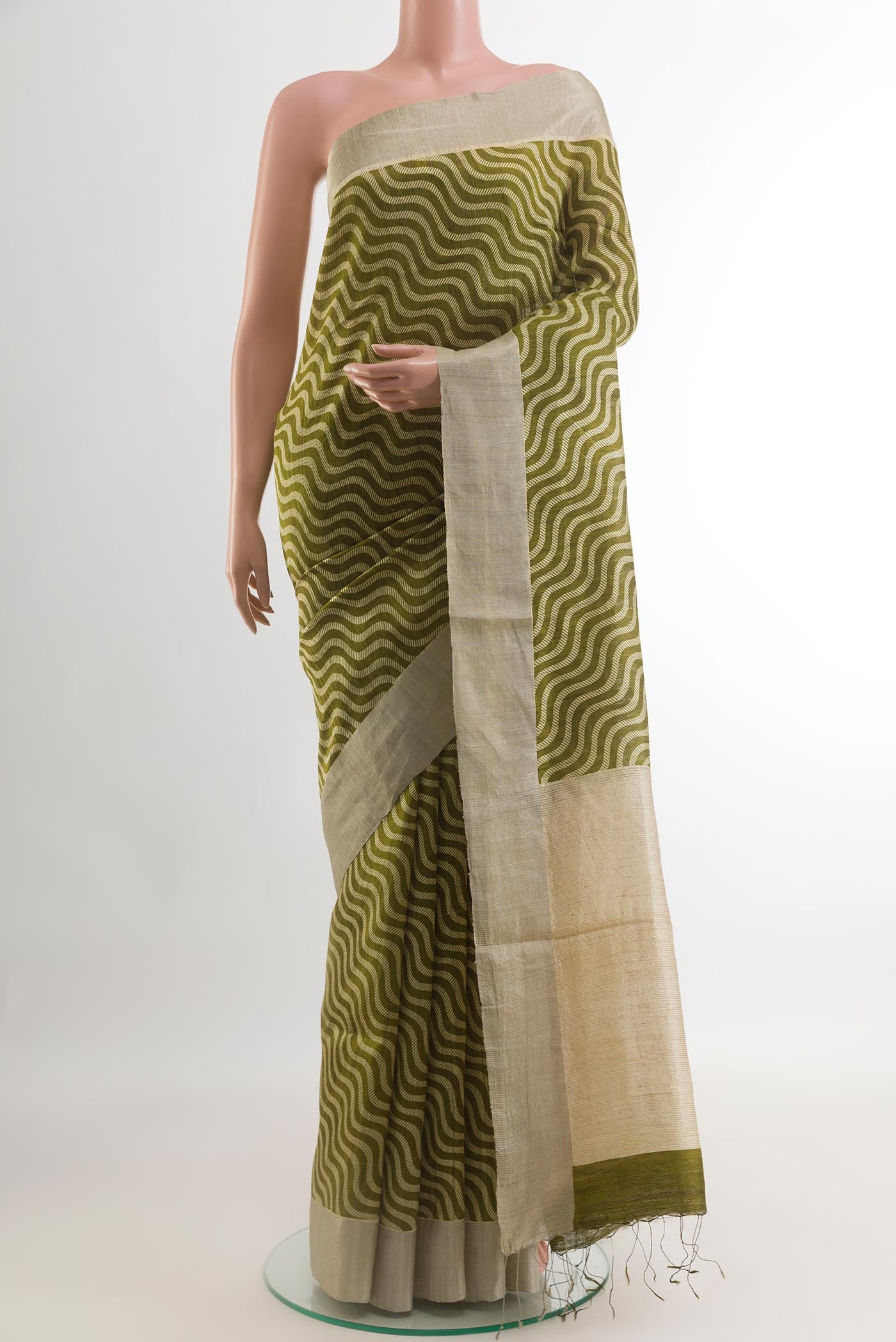 Green Tussar Silk Saree with Printed design on the body and Zari Border.  displayed on a mannequin