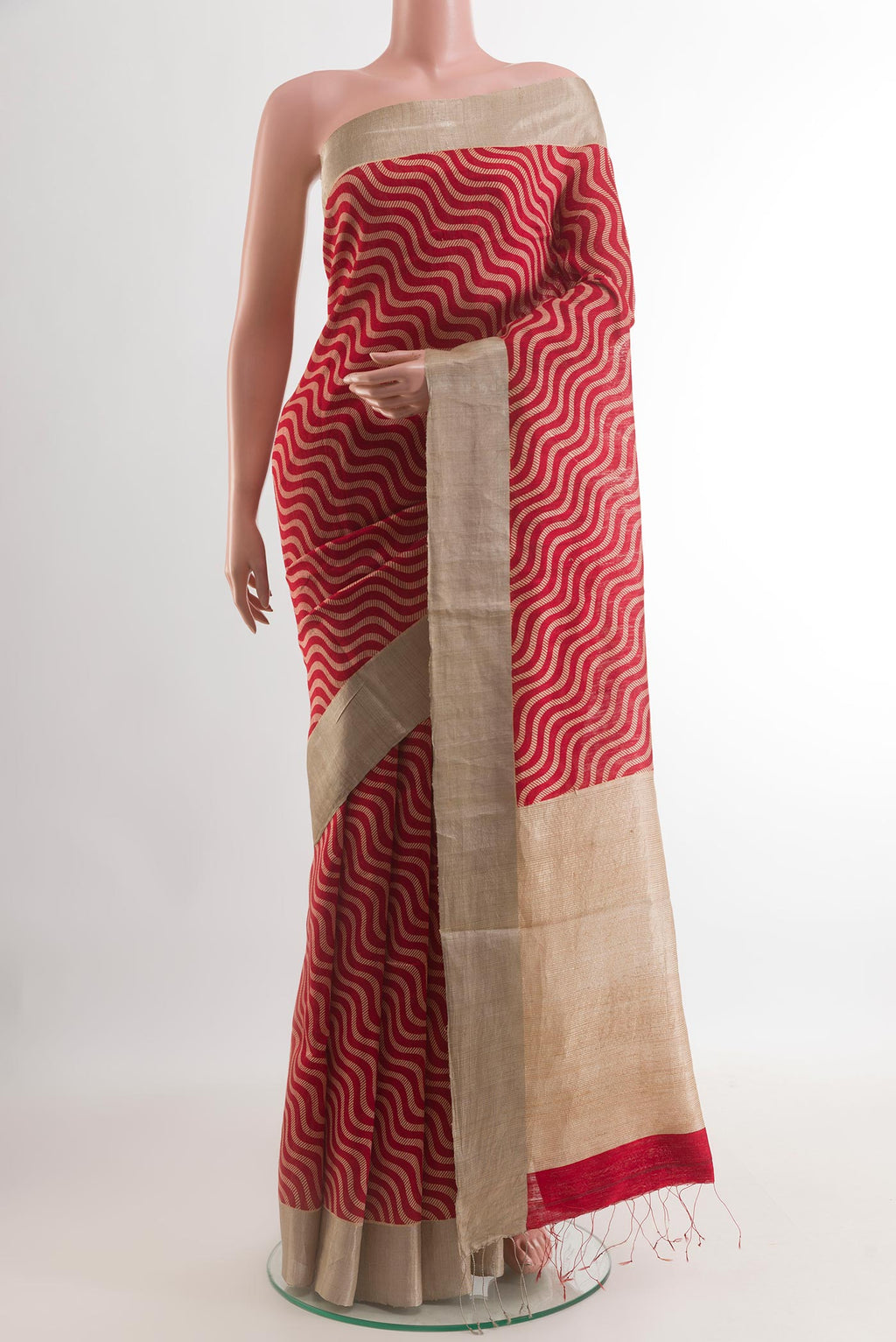 Red Tussar Silk Saree with Printed design on the body and Zari Border.  displayed on a mannequin