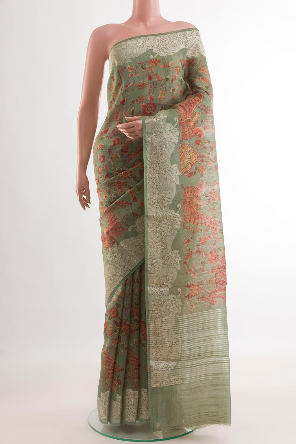 Green Tussar Silk Saree with Printed design on the body and Zari Border.  displayed on a mannequin