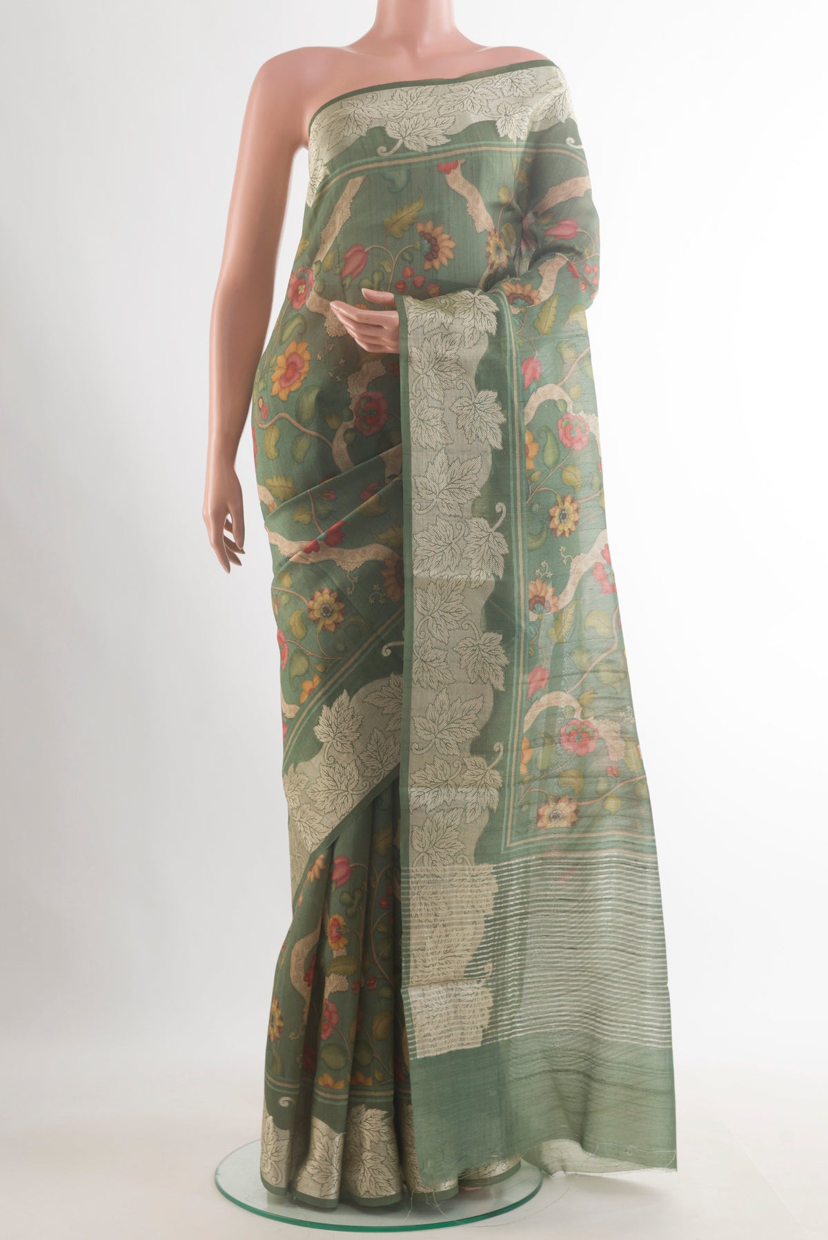 Green Tussar Saree with Printed design on the body and Zari Border.  displayed on a mannequin