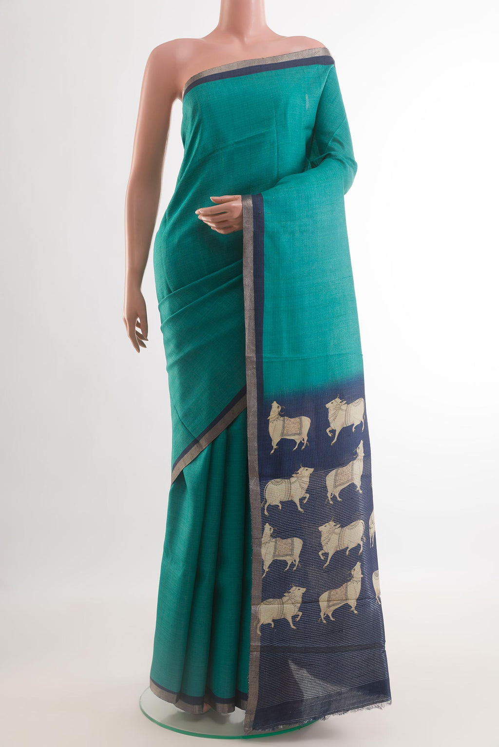 Turquoise Tussar Silk Saree with Plain Body and Printed Border.  displayed on a mannequin