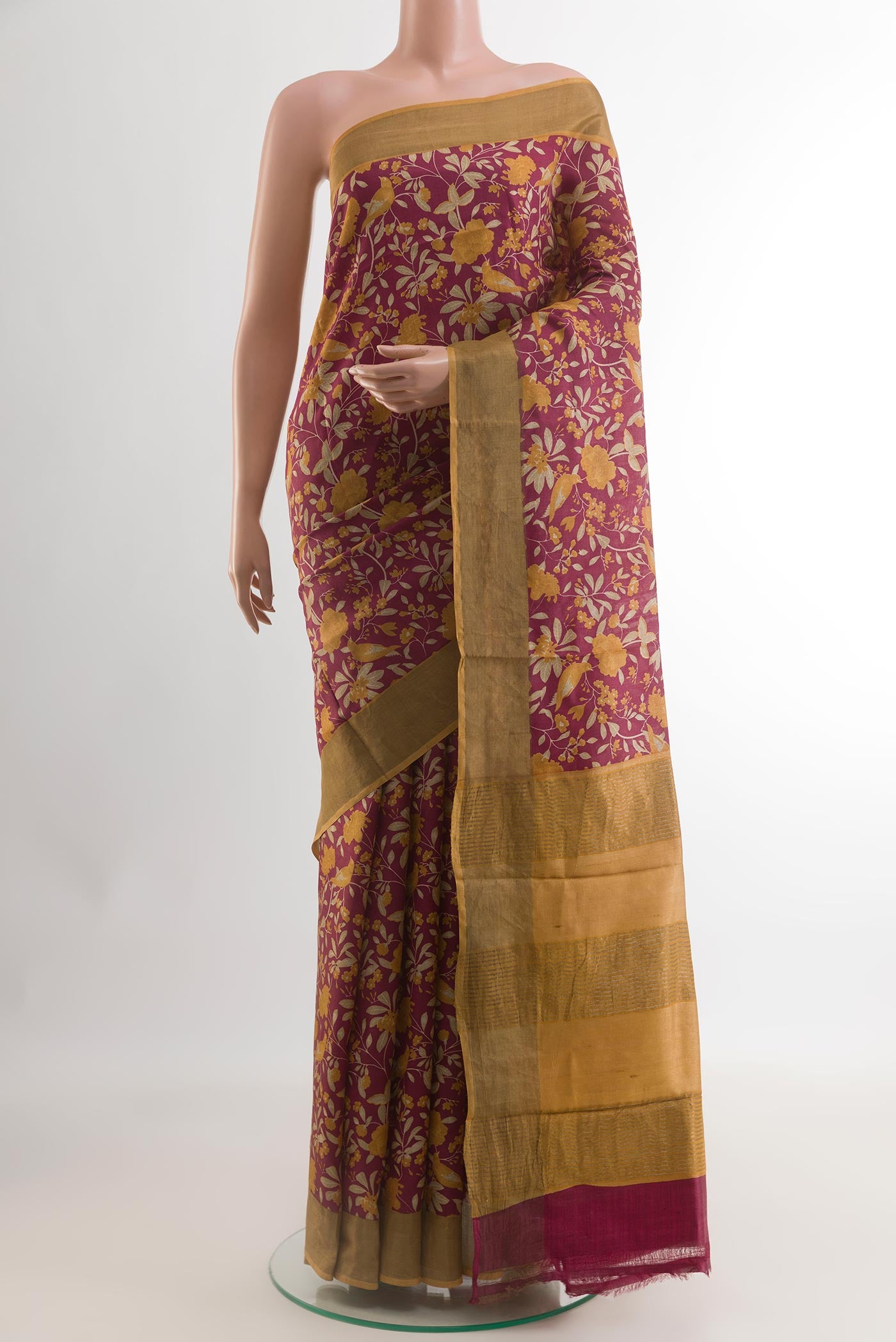 Maroon Tussar Silk Saree with Printed design on the body and Zari Border.  displayed on a mannequin