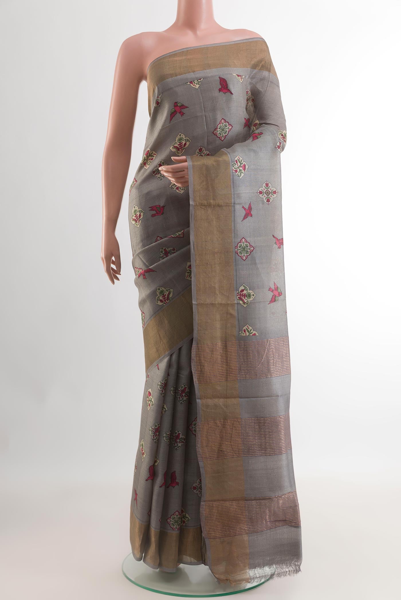 Grey Tussar Silk Saree with Printed design on the body and Zari Border.  displayed on a mannequin