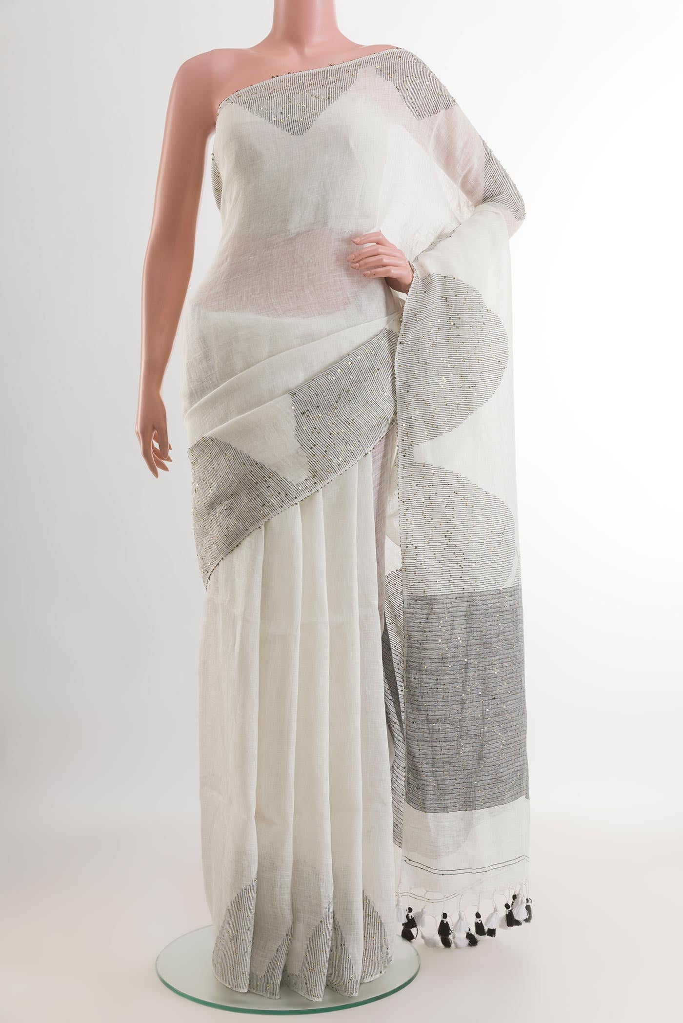 White Linen Saree with Embroidery on the body and Embroidery Border.  displayed on a mannequin
