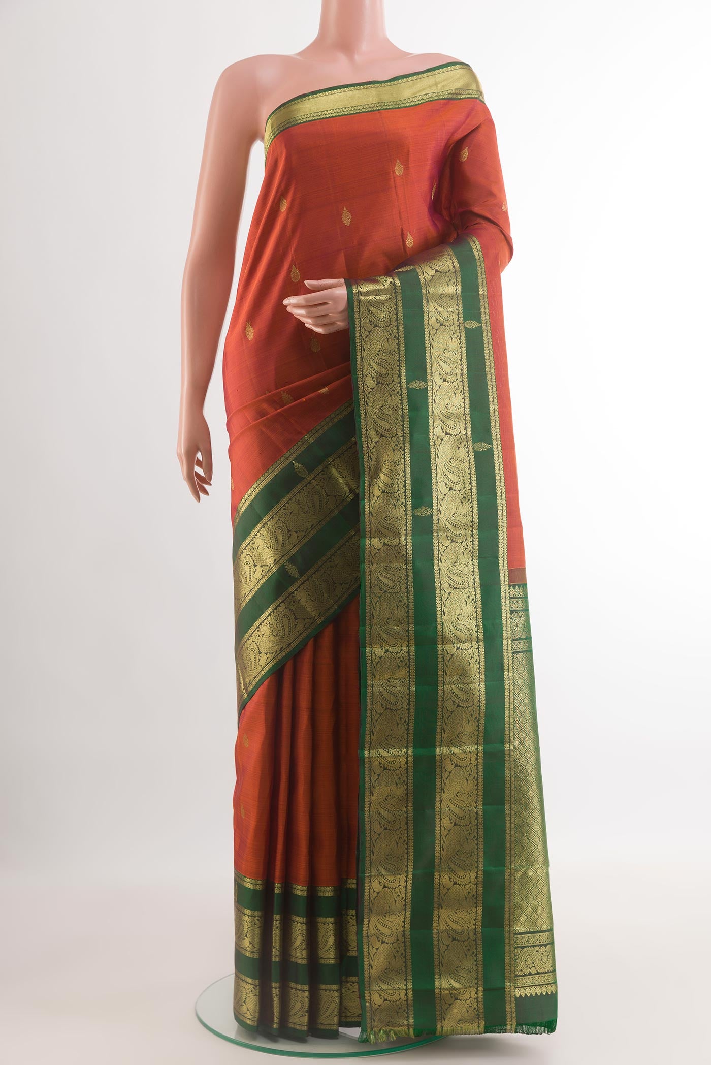 Rust Kanchipuram Silk Saree with Zari Butta on the body and Zari Border.  displayed on a mannequin
