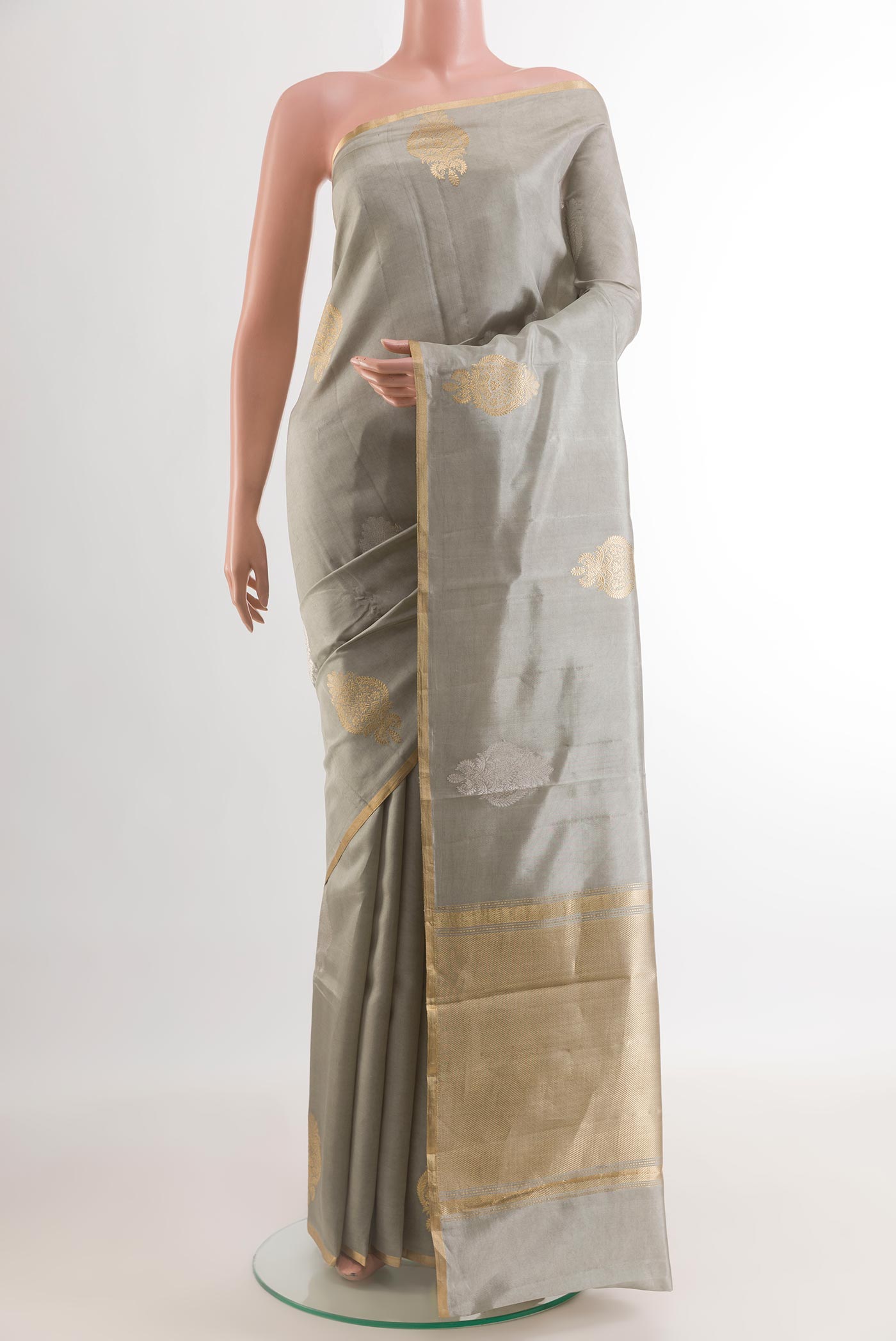 Grey Banarasi Katan Silk Saree with Zari Butta on the body and Zari Border.  displayed on a mannequin