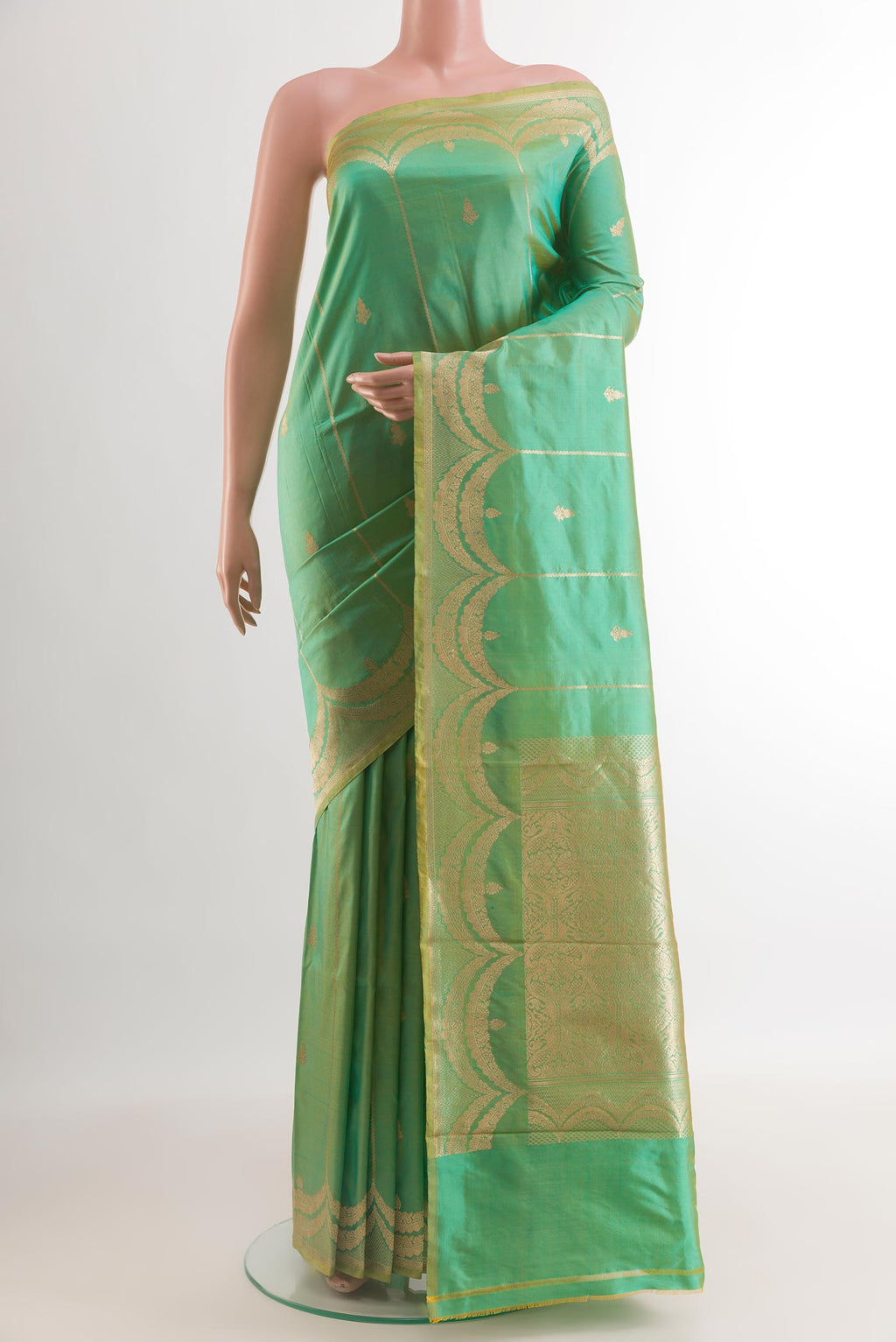 Green Banarasi Katan Silk Saree with Zari Butta on the body and Zari Border.  displayed on a mannequin