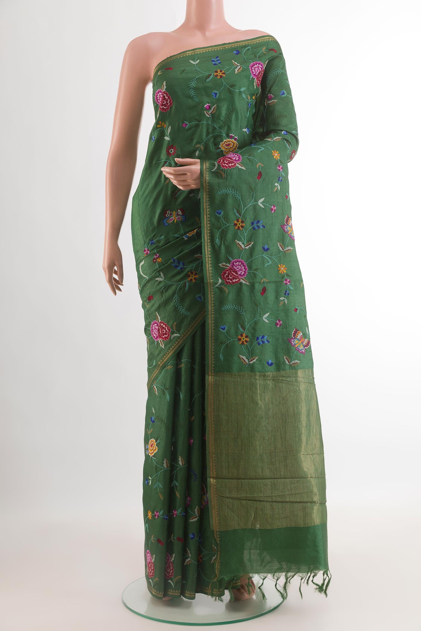 Green Tussar Silk Saree with Embroidery on the body and Zari Border.  displayed on a mannequin