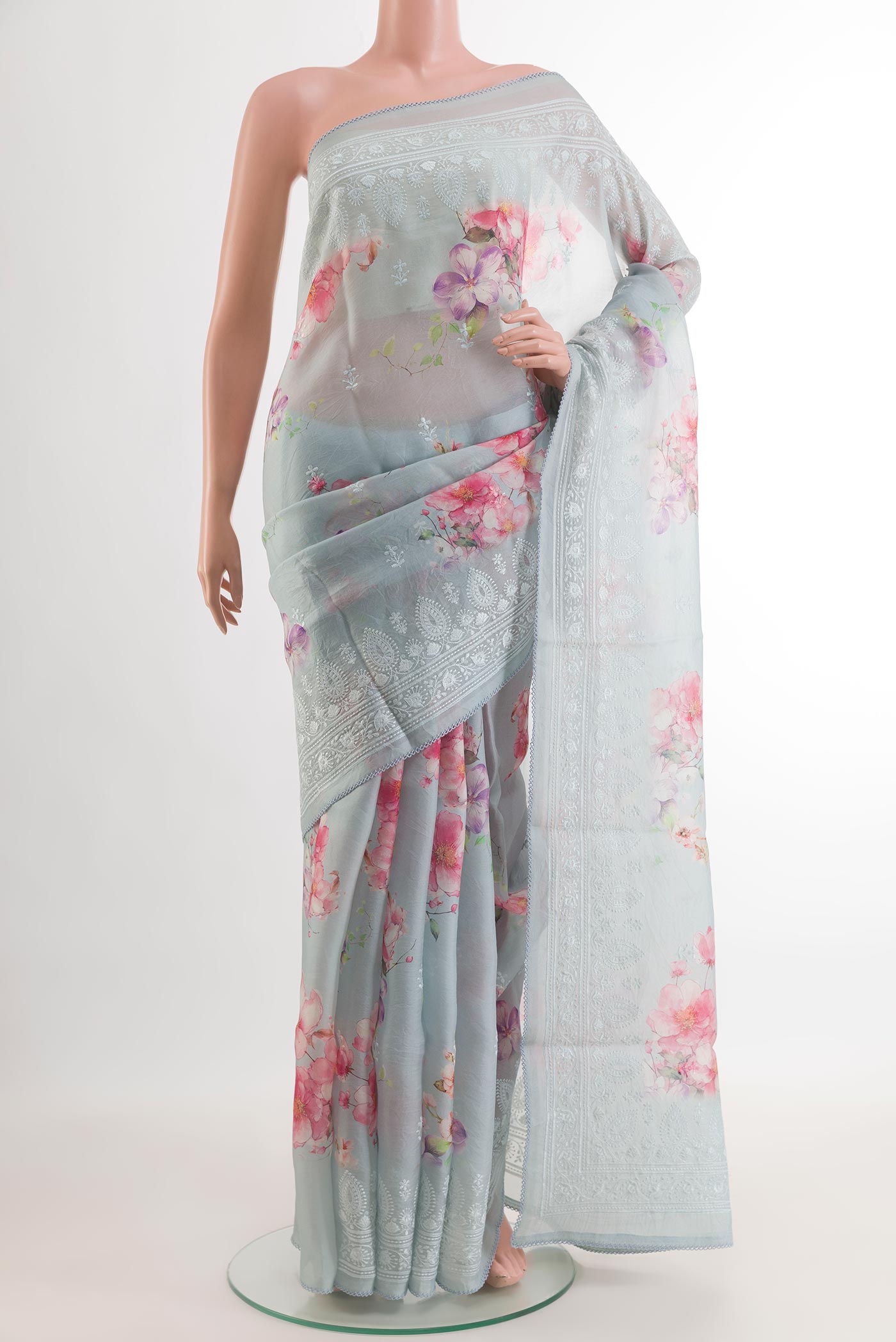 Grey Organza Silk Saree with Floral Print on the body and Embroidery Border.  displayed on a mannequin