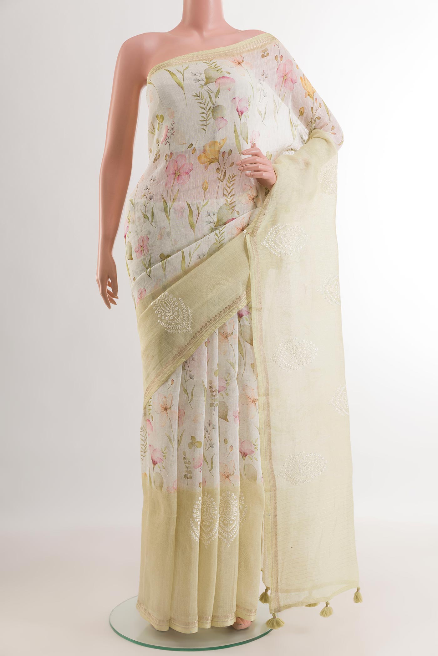 Off White Linen Saree with Floral Print on the body and Zari Border.  displayed on a mannequin