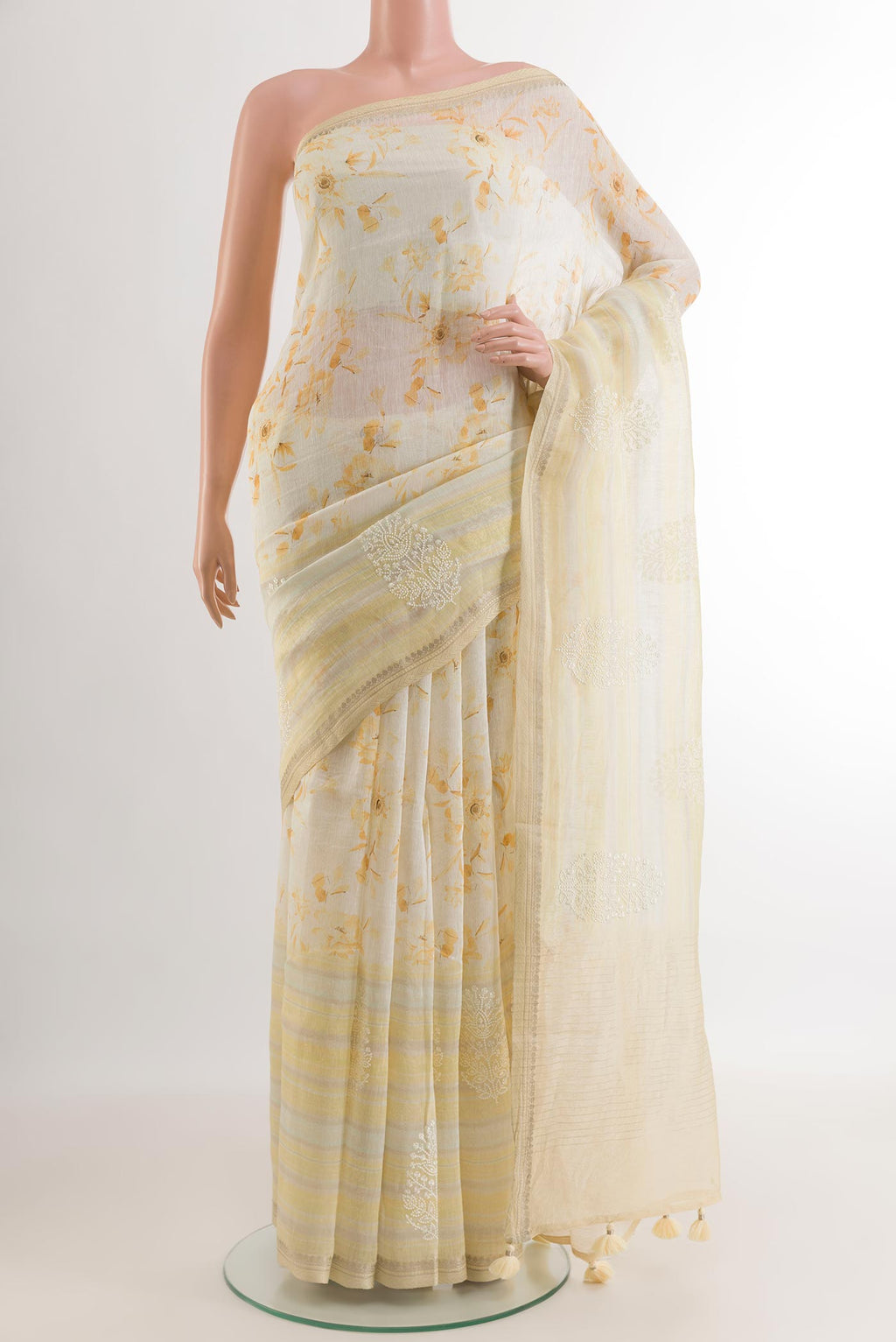 Off White Linen Saree with Floral Print on the body and Zari Border.  displayed on a mannequin