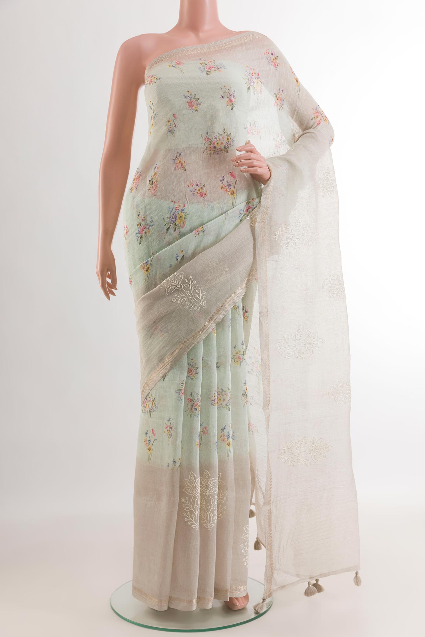 Off White Linen Saree with Floral Print on the body and Zari Border.  displayed on a mannequin