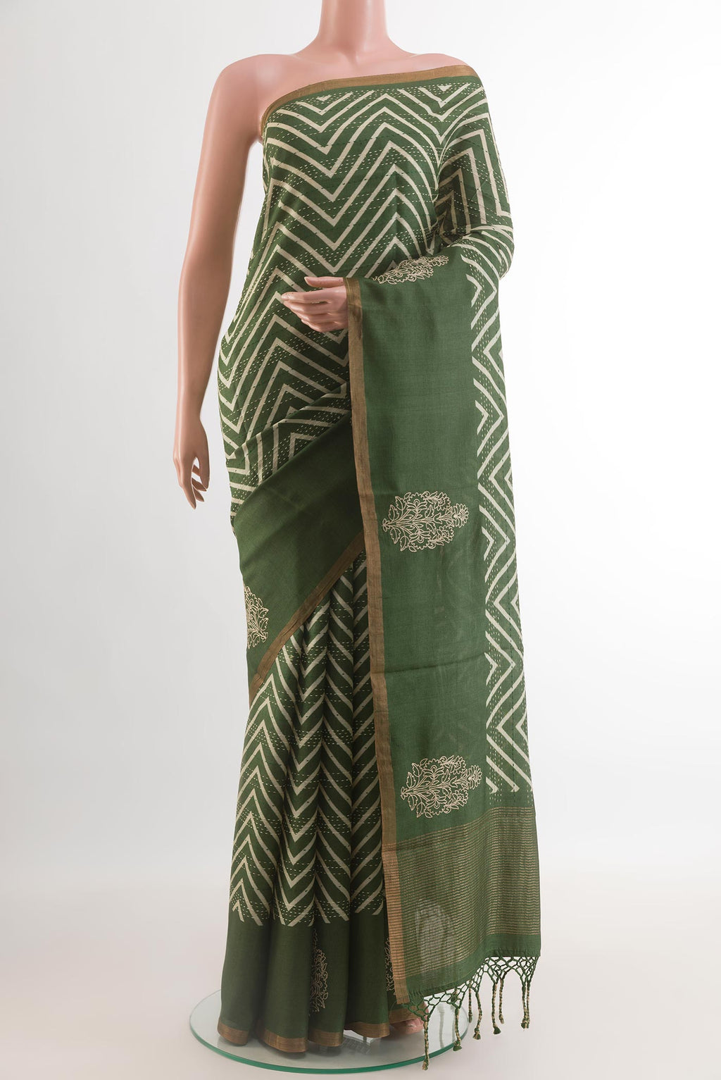 Green Tussar Silk Saree with Printed design on the body and Zari Border.  displayed on a mannequin