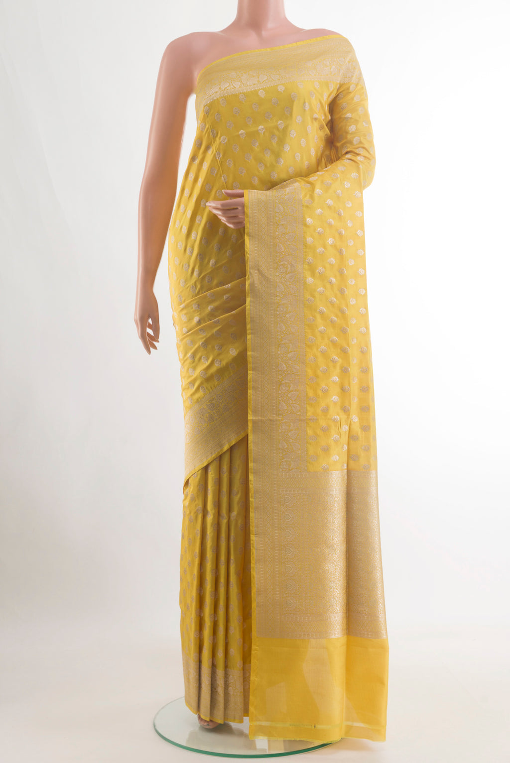 Mustard Banarasi Silk Saree with Zari Butta on the body and Zari Border.  displayed on a mannequin