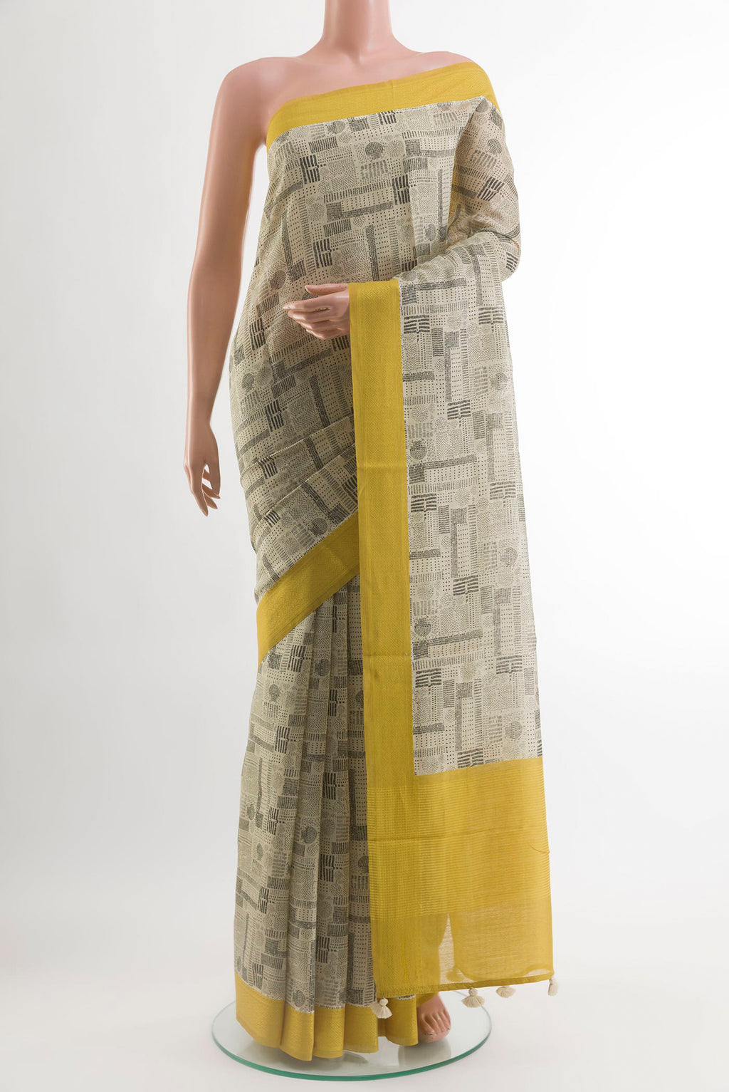Beige Tussar Silk Saree with Printed design on the body and Embroidery Border.  displayed on a mannequin
