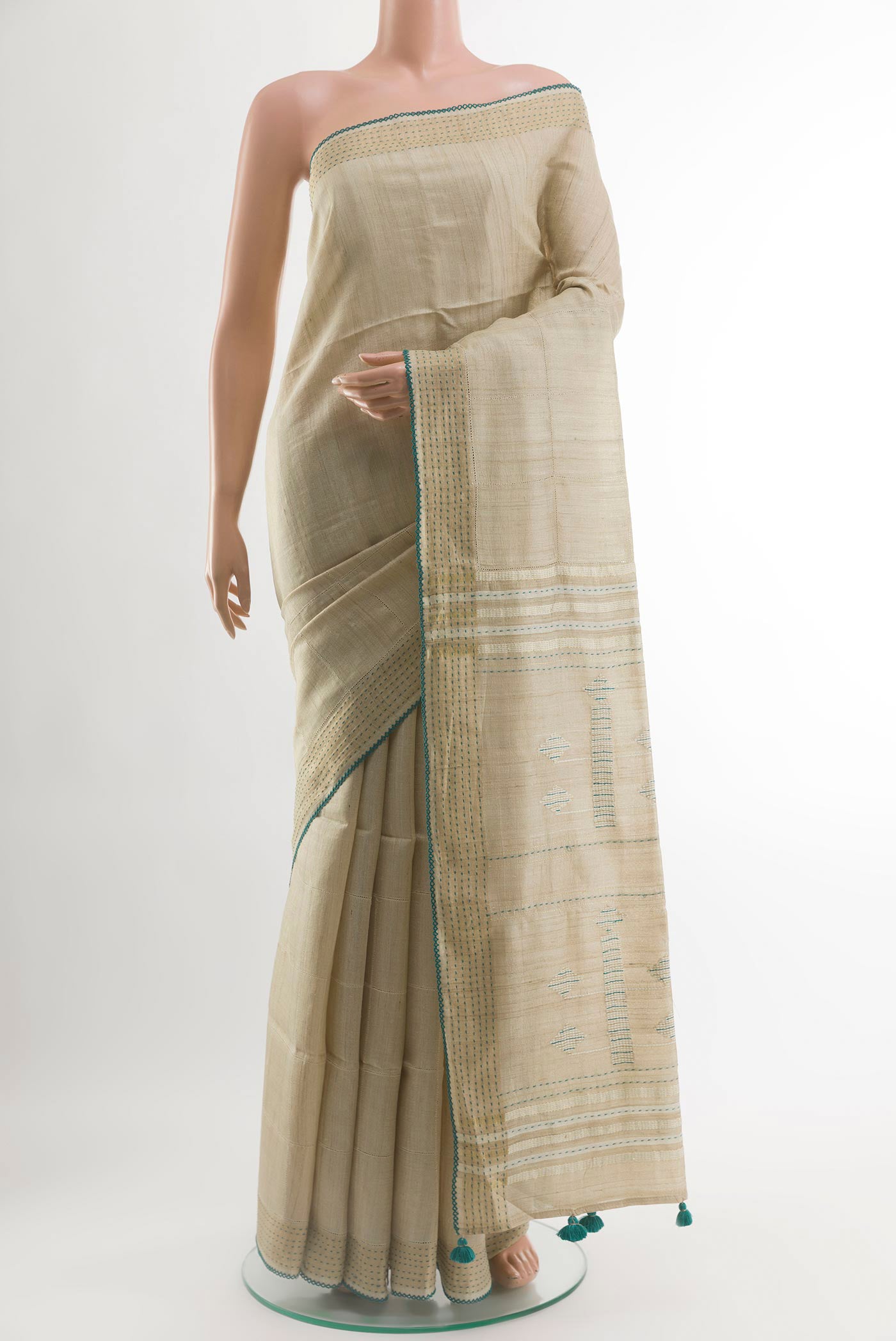 Beige Tussar Silk Saree with Embroidery on the body and Embroidery Border.  displayed on a mannequin