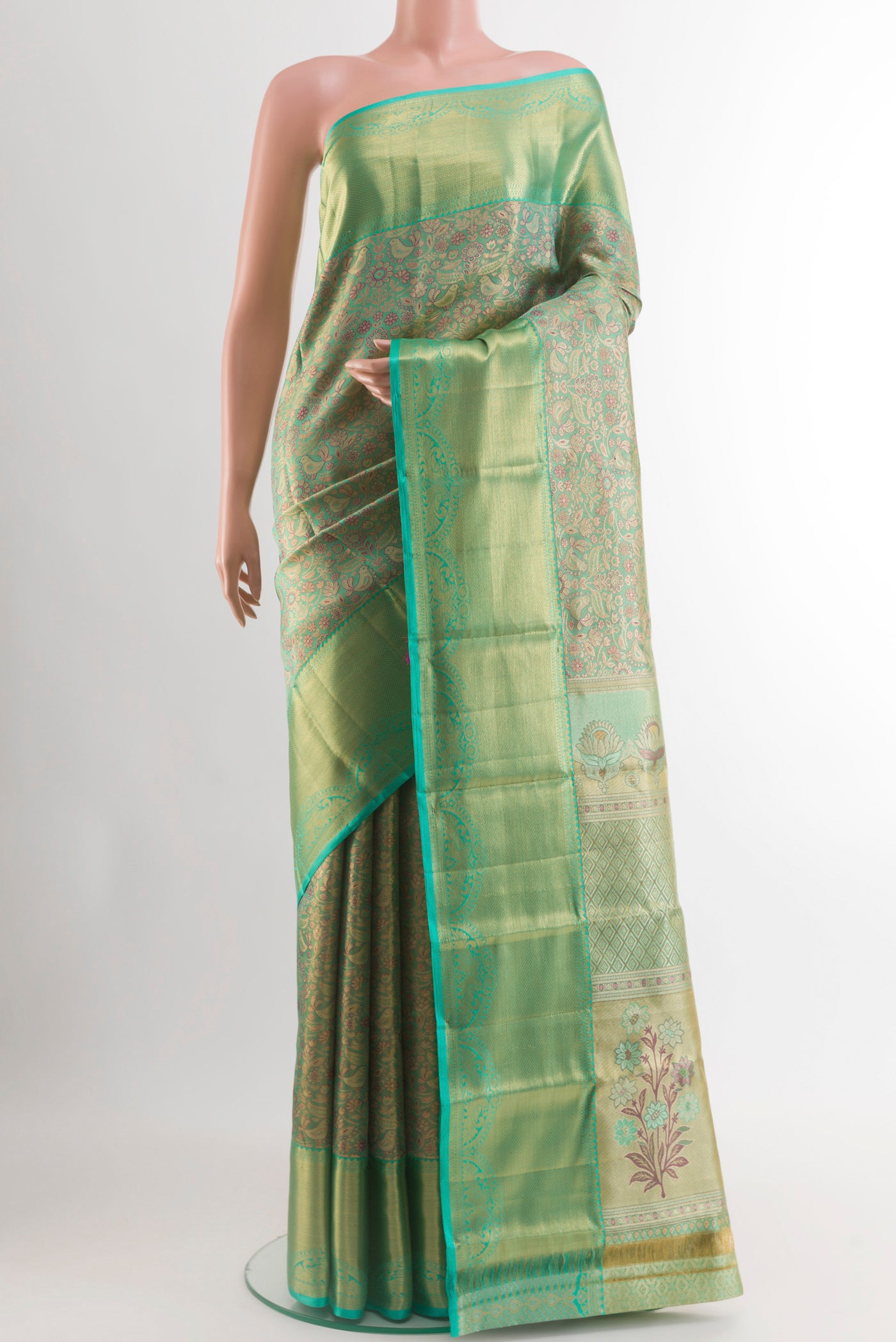 Green Kanjivaram Tissue Silk Saree with Zari Brocade on the body and Zari Border.  displayed on a mannequin