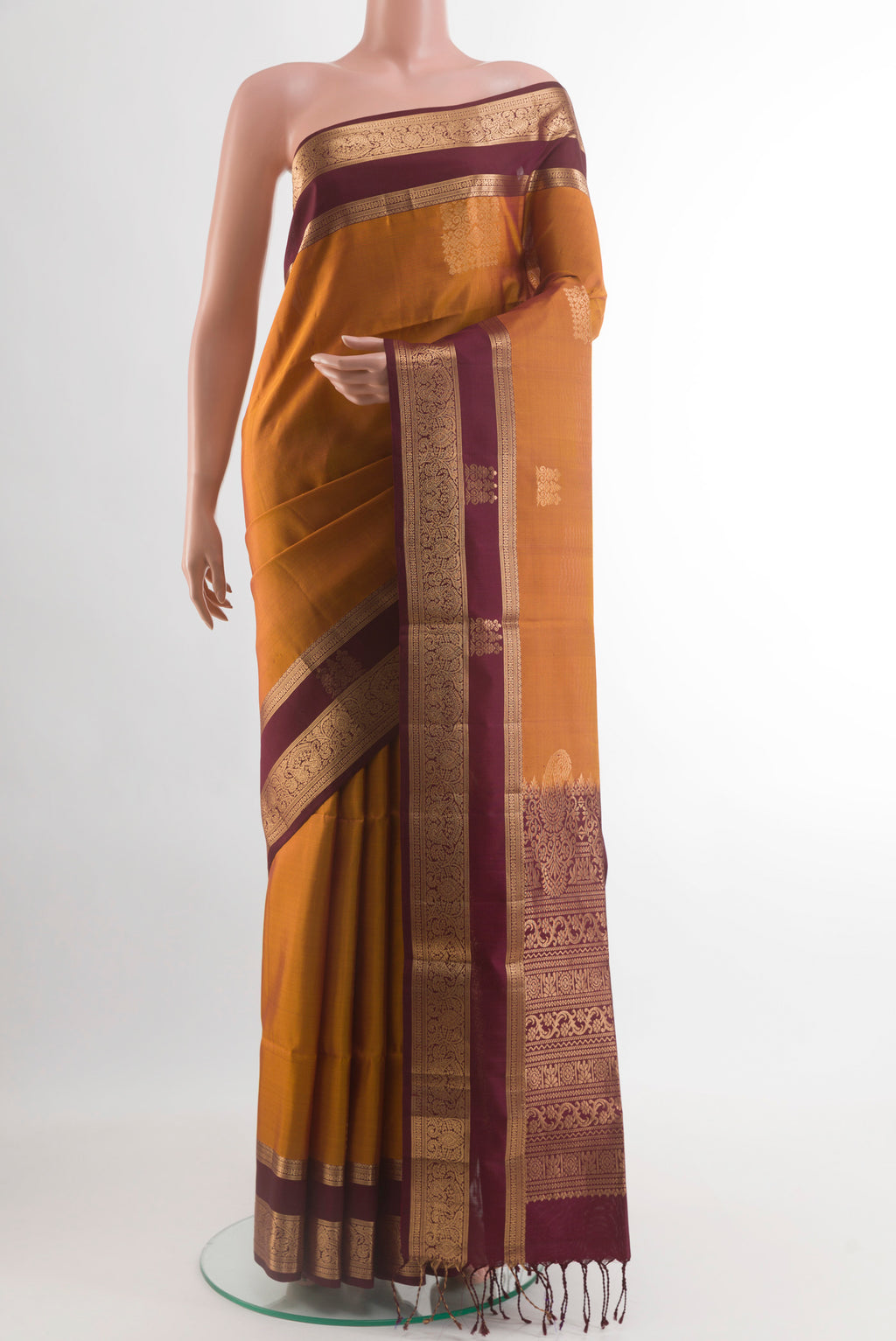 Mustard Soft Silk Saree with Zari Butta on the body and Zari Border.  displayed on a mannequin