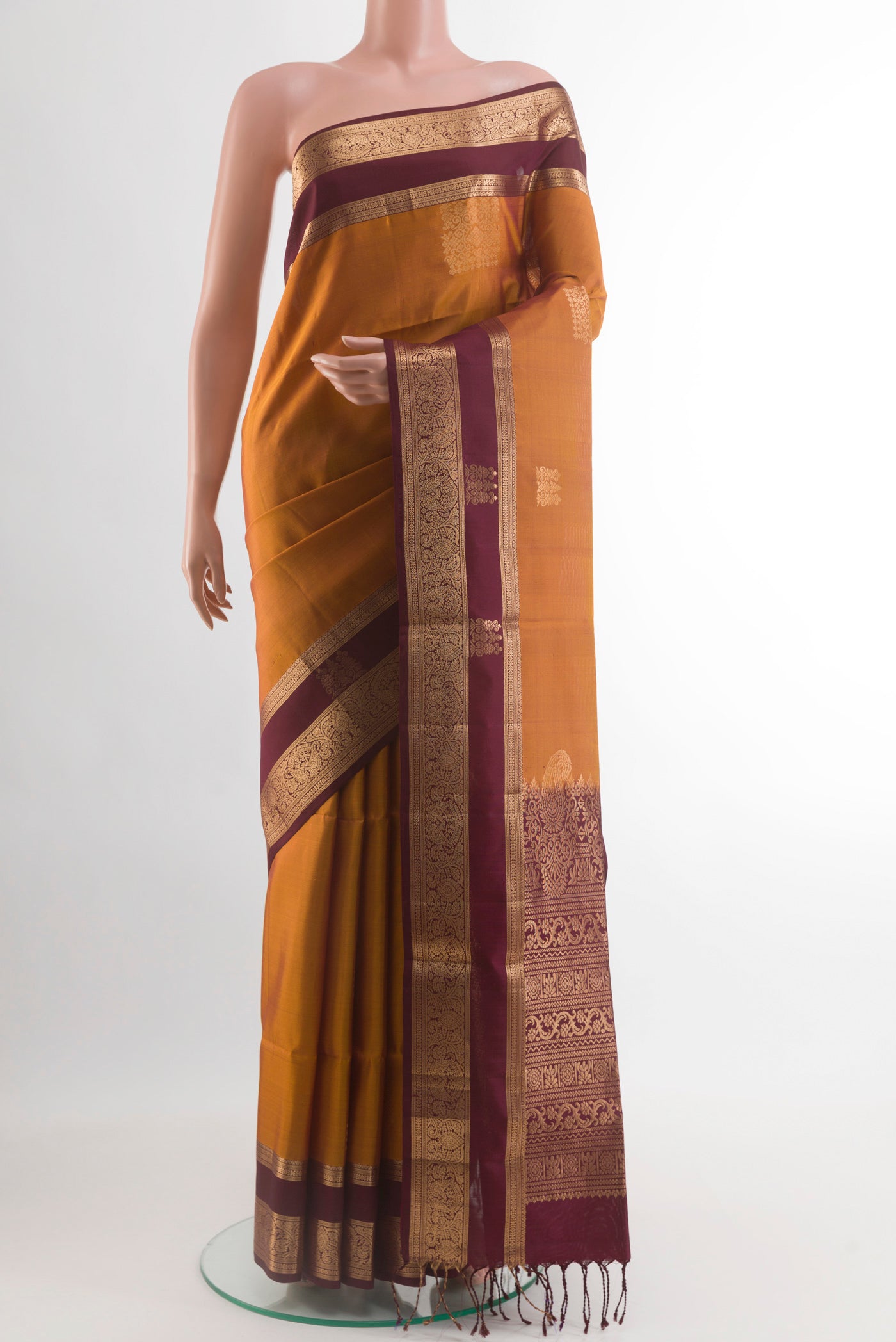 Mustard Soft Silk Saree with Zari Butta on the body and Zari Border.  displayed on a mannequin