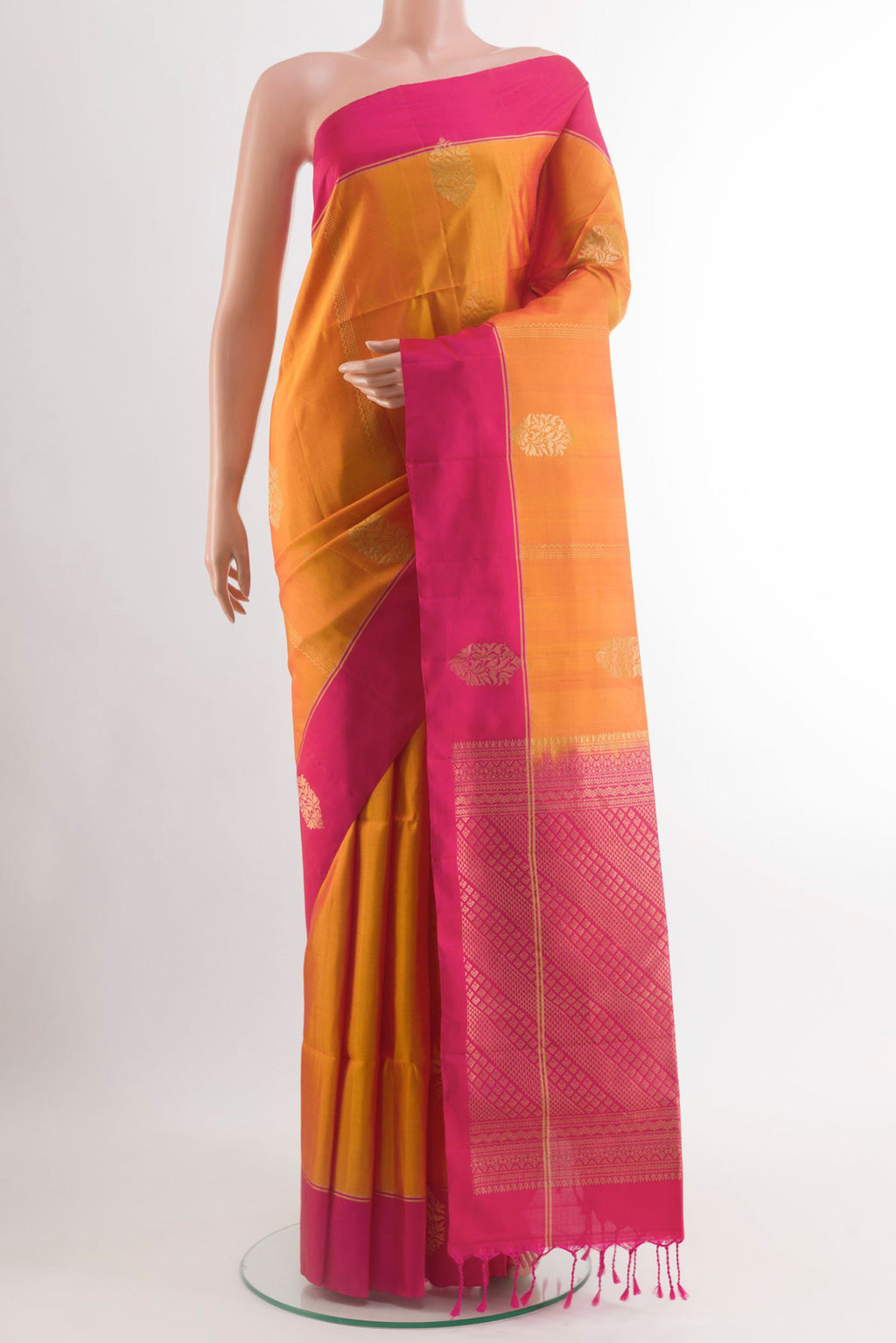 Mustard Soft Silk Saree with Zari Butta on the body and Plain Border.  displayed on a mannequin