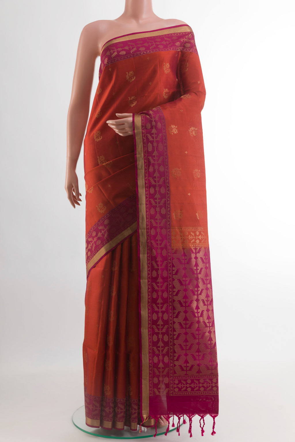 Brick Orange Soft Silk Saree with Zari Butta on the body and Zari Border.  displayed on a mannequin