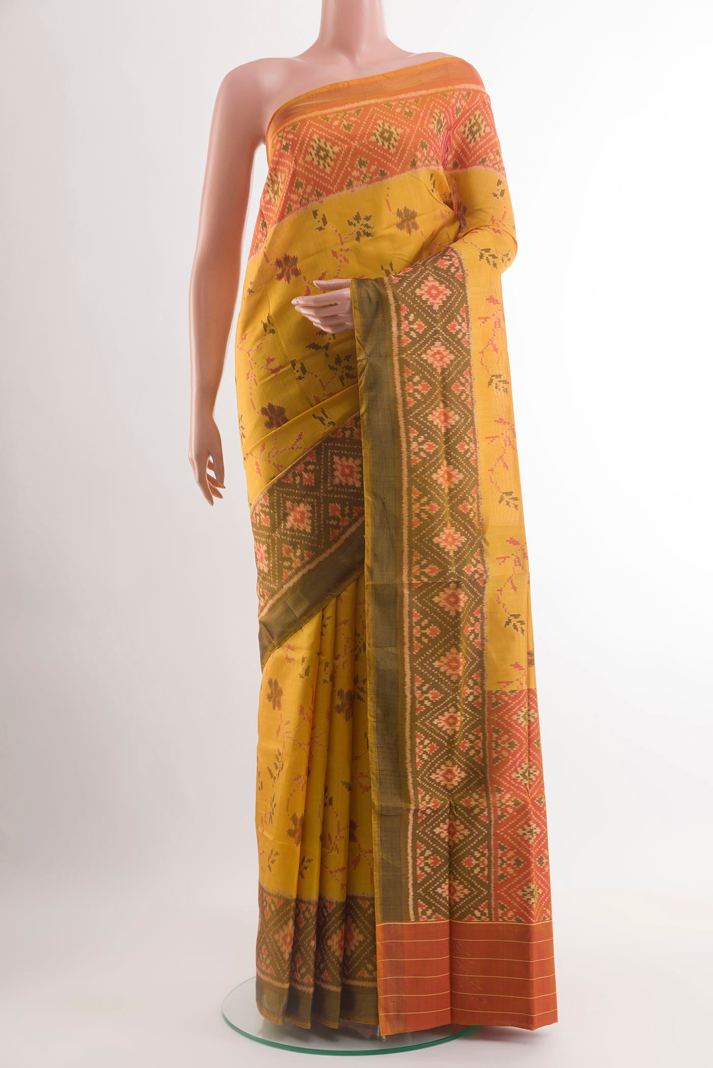 Yellow Rajkot Patola Silk Saree with Ikat design on the body and Ikat Border.  displayed on a mannequin