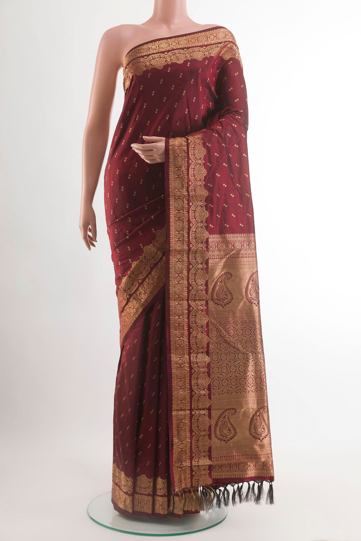 Maroon Kanjivaram Silk Saree with Zari Butta on the body and Zari Border.  displayed on a mannequin