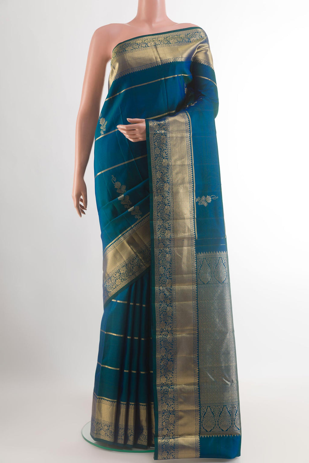 Peacock Blue Kanjivaram Silk Saree with Zari Butta on the body and Zari Border.  displayed on a mannequin