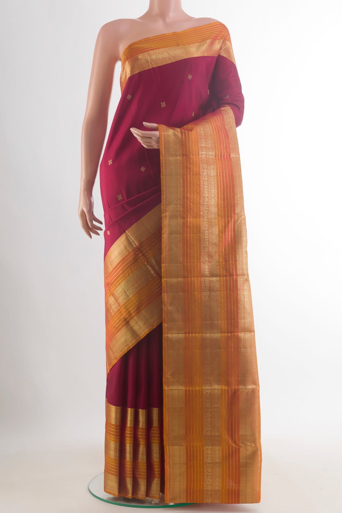 Pure Silk Maroon Kanjivaram Saree with Zari Butta on the body and Zari Border.  displayed on a mannequin