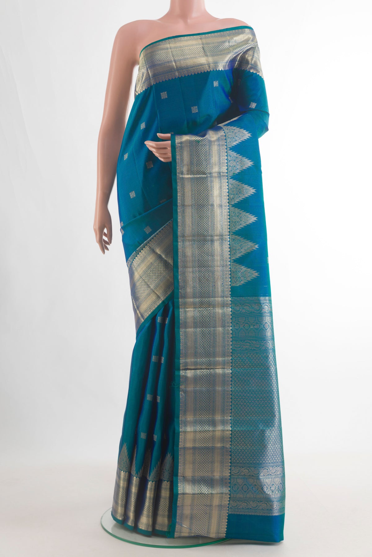 Pure Silk Peacock Blue Kanjivaram Saree with Zari Butta on the body and Zari Border.  displayed on a mannequin