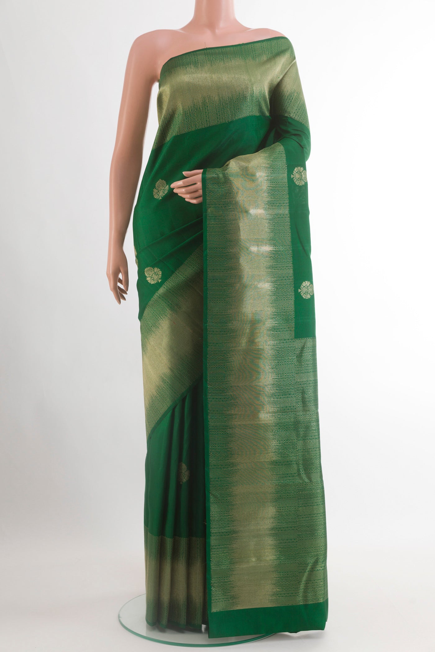 Green Kanjivaram Silk Saree with Zari Butta on the body and Zari Border.  displayed on a mannequin
