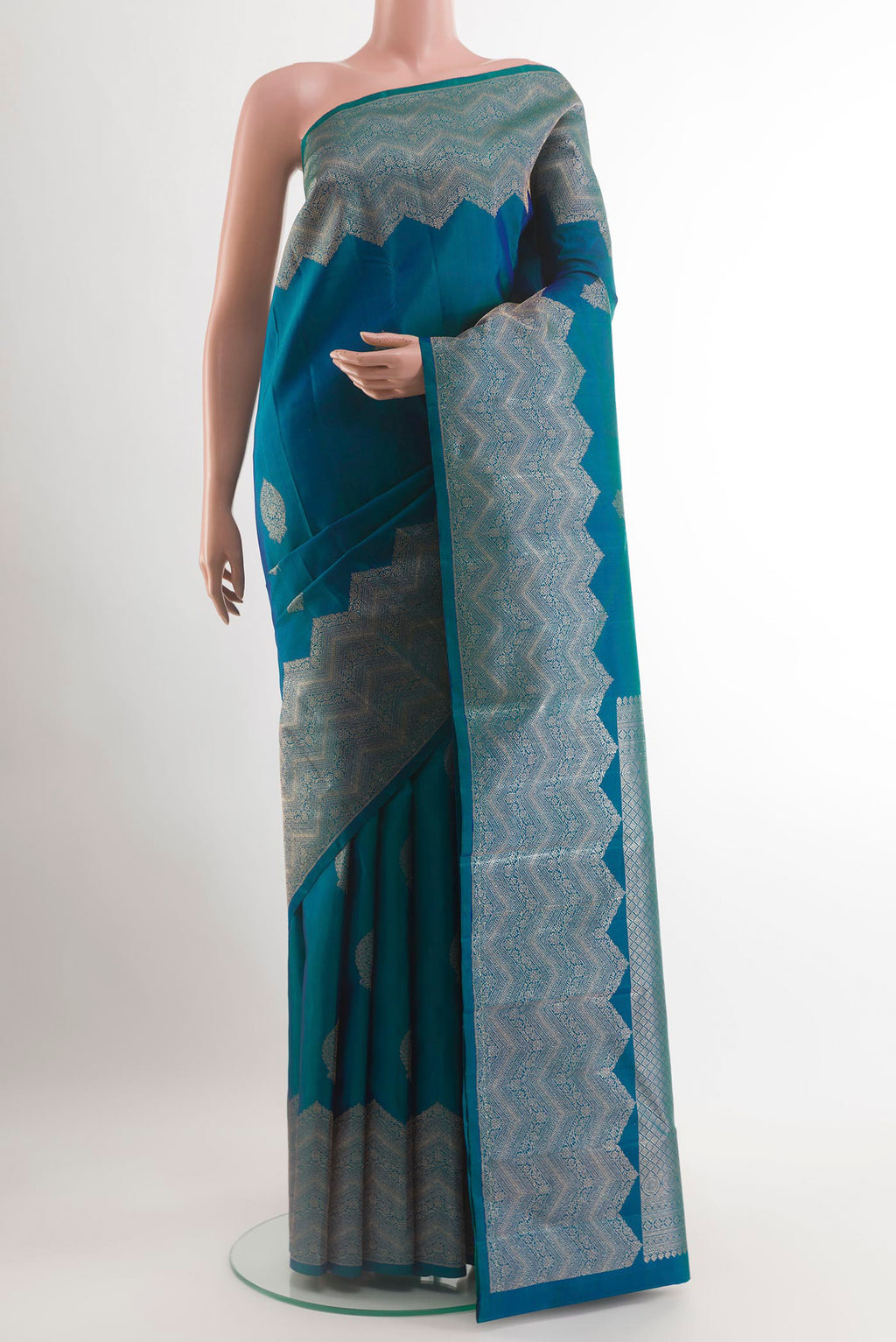 Peacock Blue Kanjivaram Silk Saree with Zari Butta on the body and Zari Border.  displayed on a mannequin