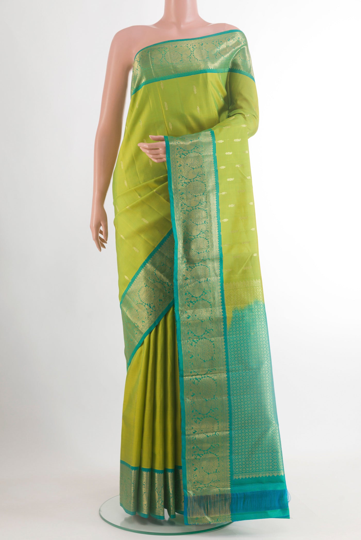 Green Kanchipuram Silk Saree with Zari Butta on the body and Zari Border.  displayed on a mannequin