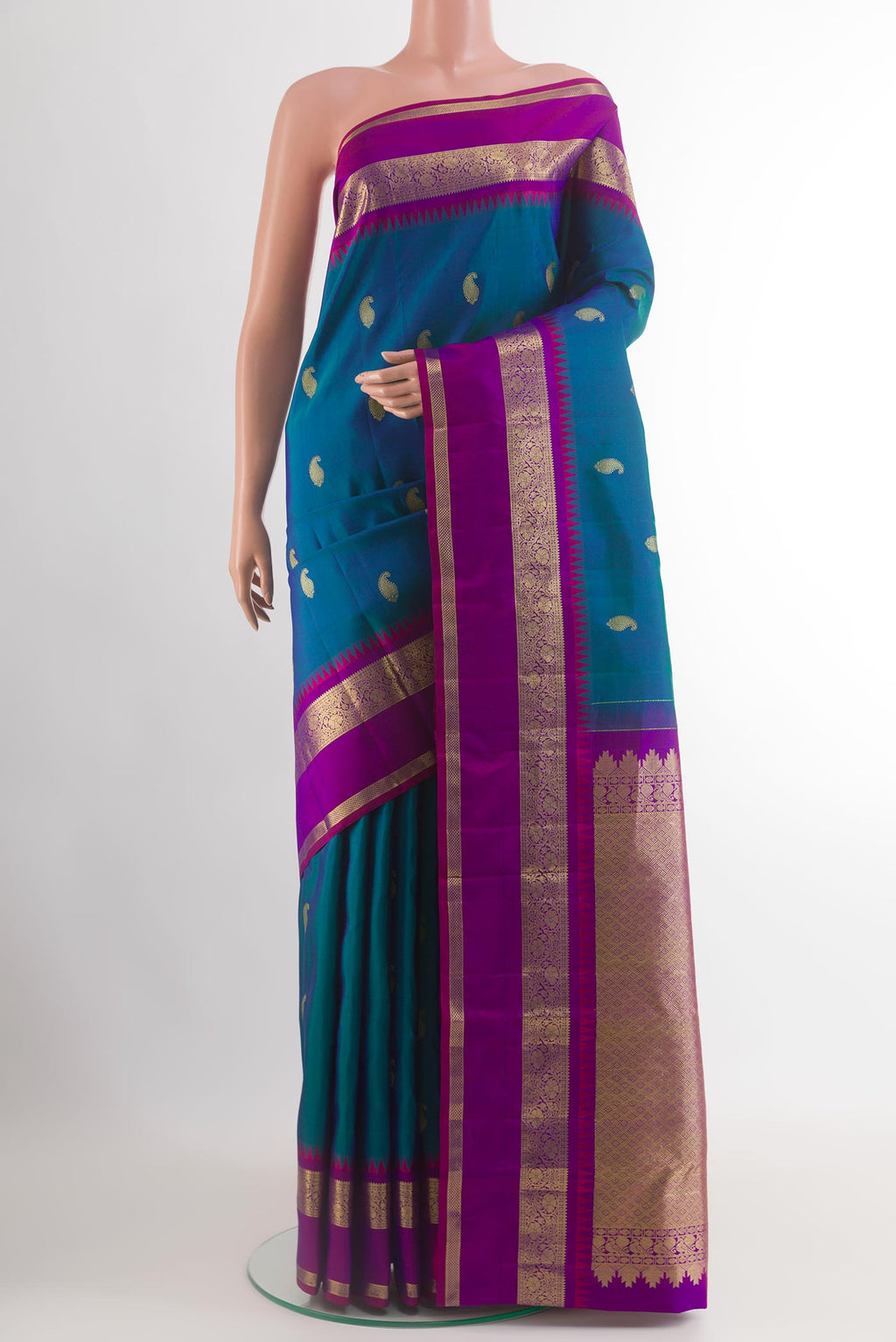 Peacock Blue Kanchipuram Silk Saree with Zari Butta on the body and Zari Border.  displayed on a mannequin