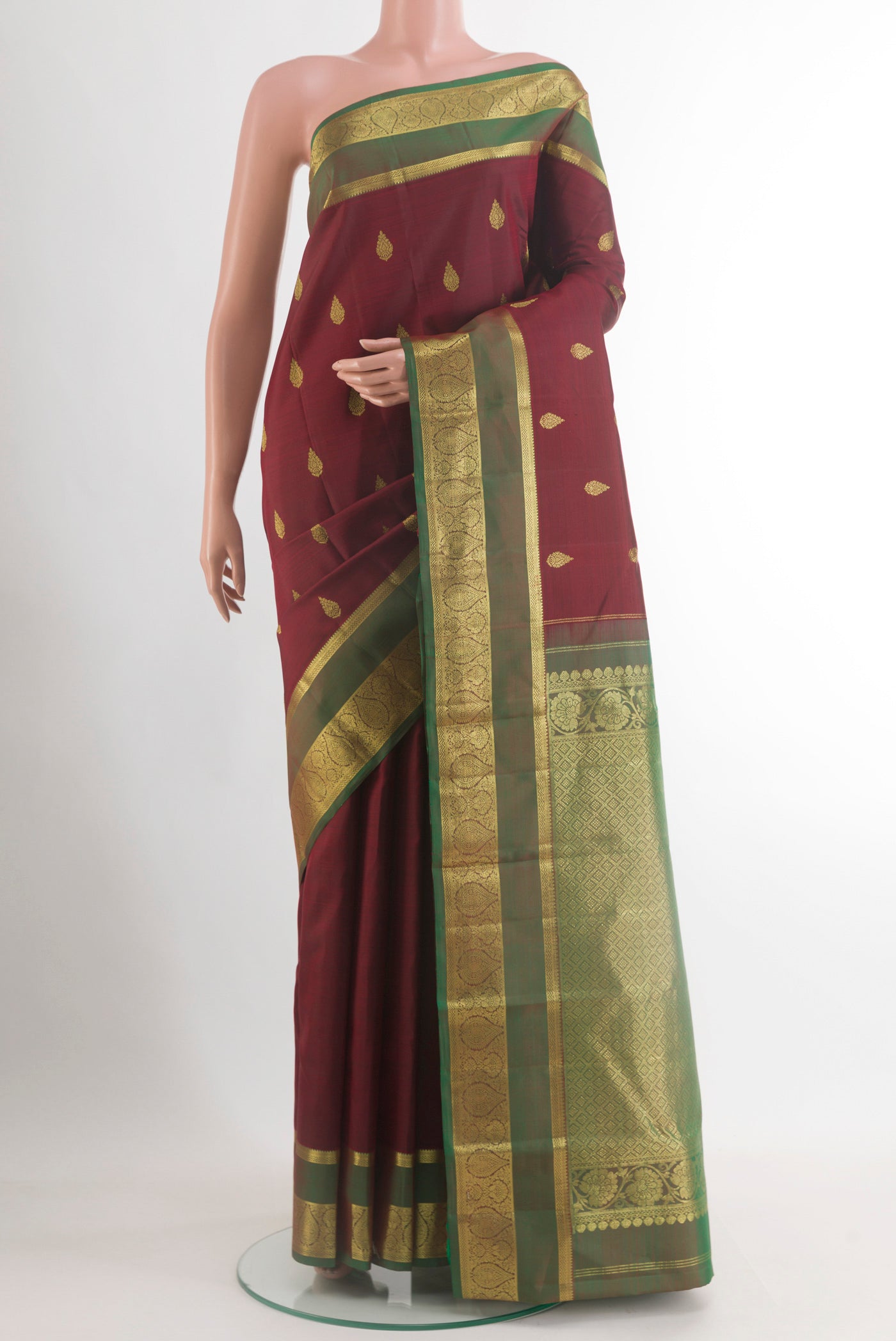 Maroon Kanchipuram Silk Saree with Zari Butta on the body and Zari Border.  displayed on a mannequin
