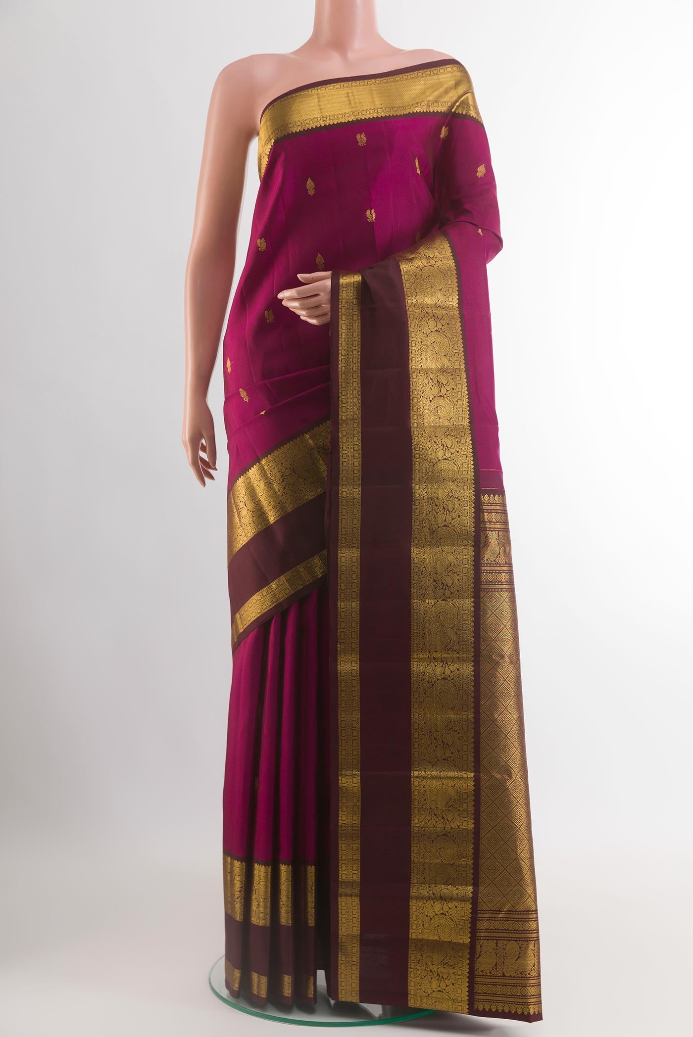 Magenta Kanchipuram Silk Saree with Zari Butta on the body and Zari Border.  displayed on a mannequin