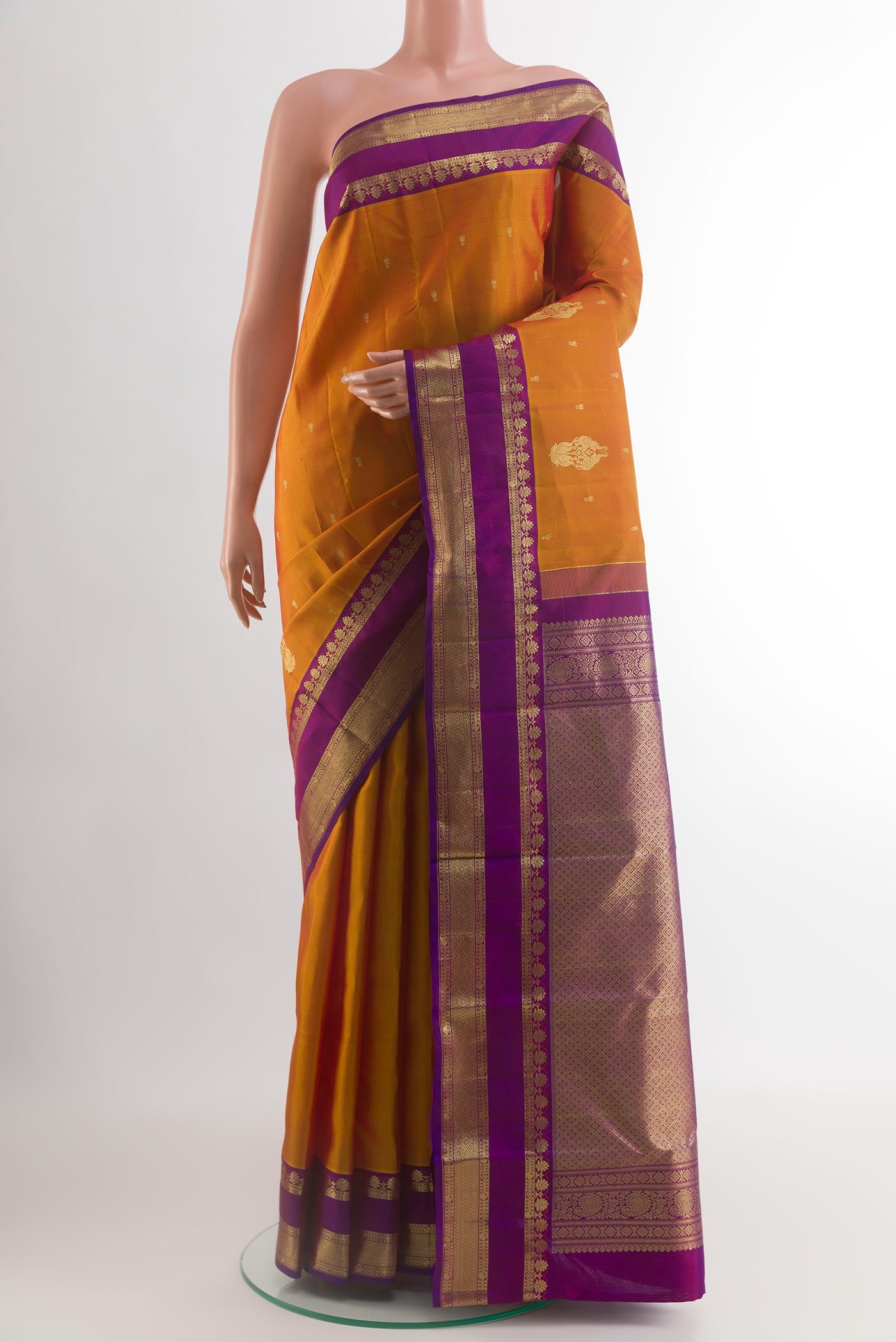 Mustard Kanchipuram Silk Saree with Zari Brocade on the body and Zari Border.  displayed on a mannequin