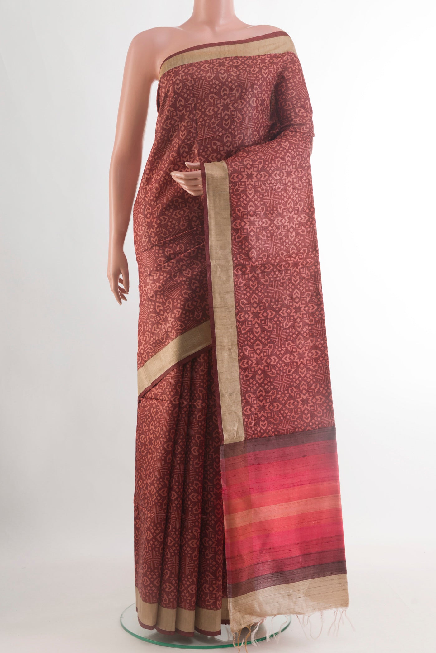 Brown Tussar Silk Saree with Printed design on the body and Zari Border.  displayed on a mannequin