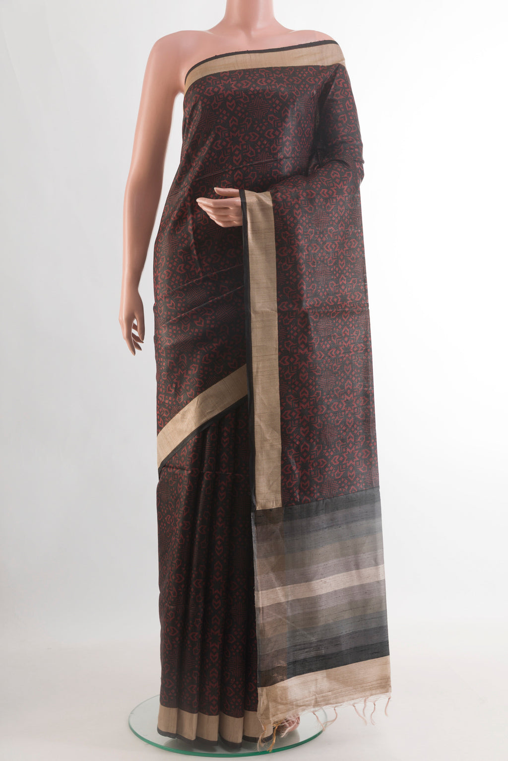 Black Tussar Silk Saree with Printed design on the body and Zari Border.  displayed on a mannequin