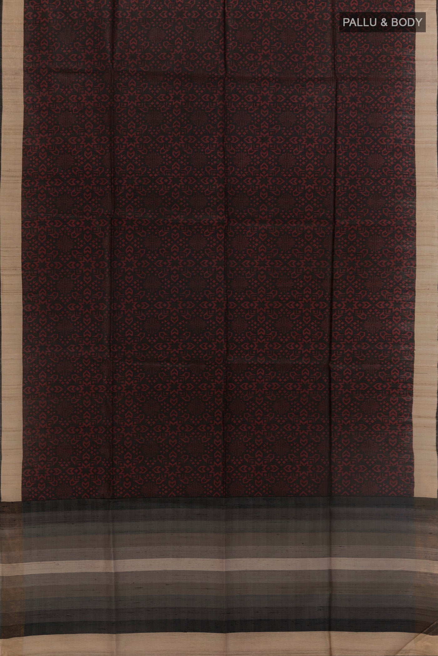 Flat view of Black Tussar Silk Saree with Printed design on the body and Zari Border. 