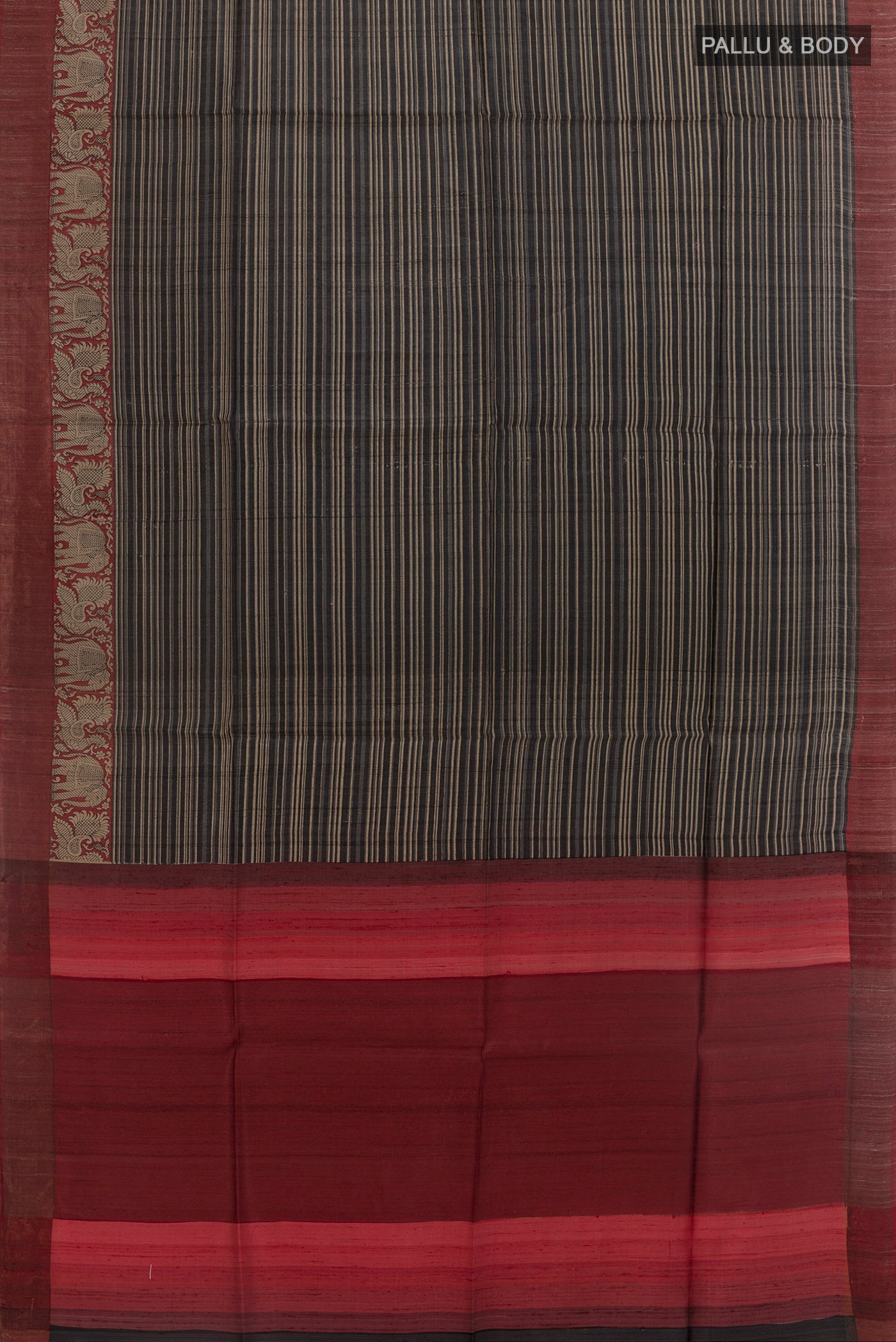 Flat view of Black Tussar Silk Saree with Printed design on the body and Zari Border. 