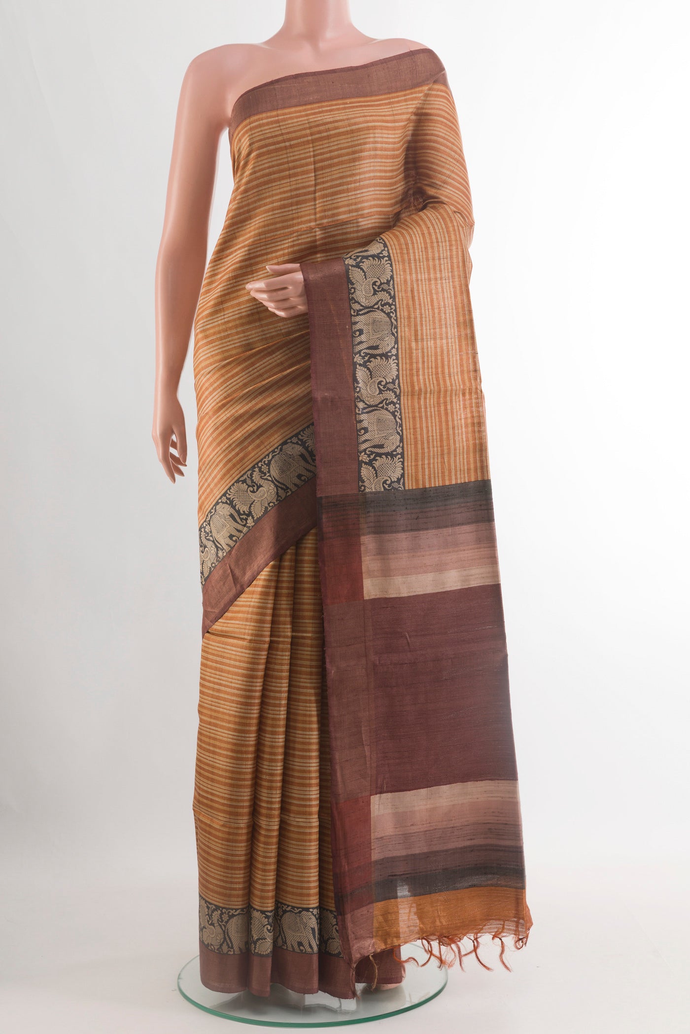 Mustard Tussar Silk Saree with Stripes on the body and Zari Border.  displayed on a mannequin