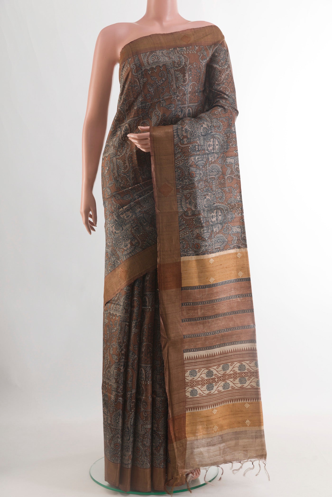 Brown Tussar Silk Saree with Printed design on the body and Zari Border.  displayed on a mannequin