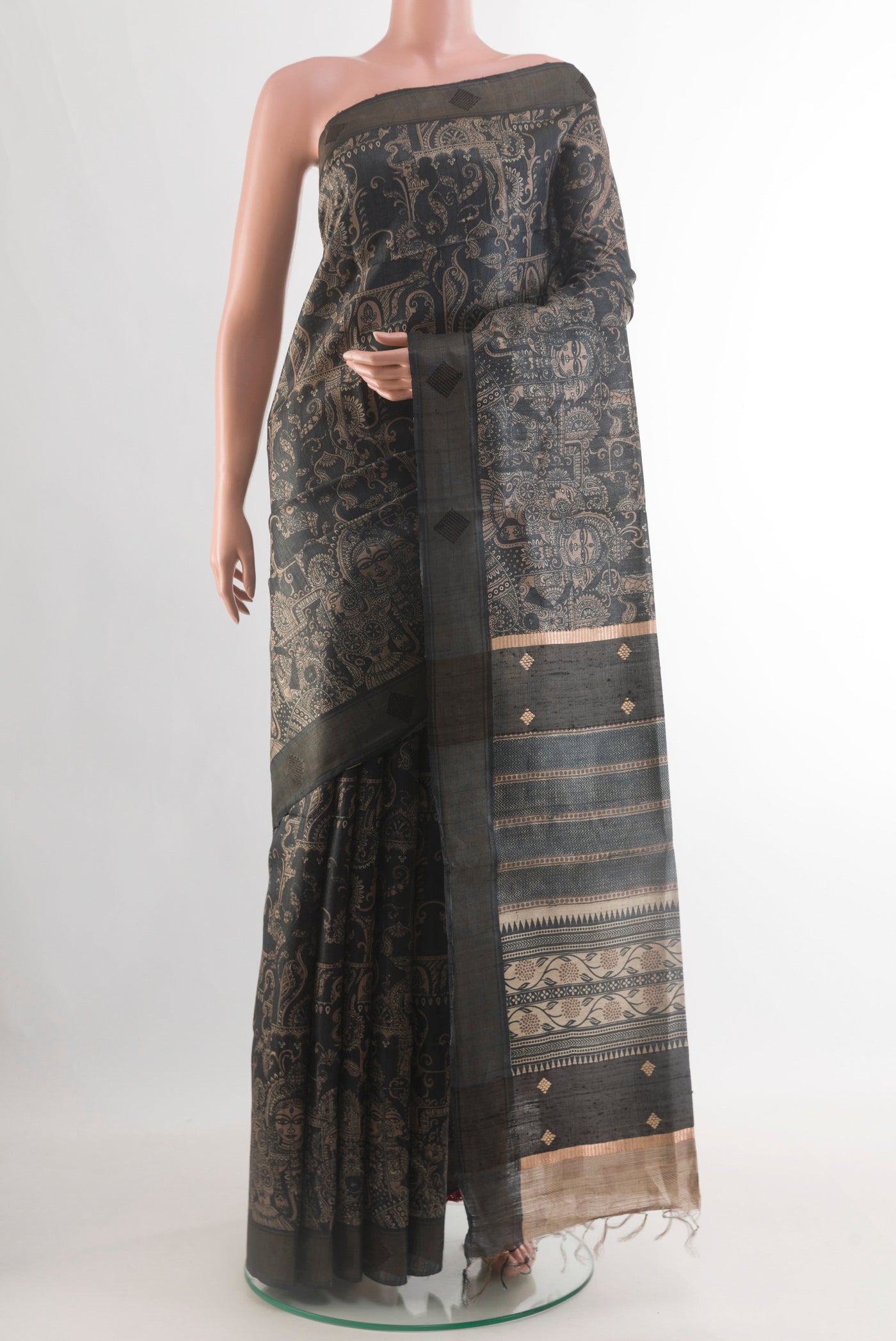 Black Tussar Silk Saree with Printed design on the body and Zari Border.  displayed on a mannequin