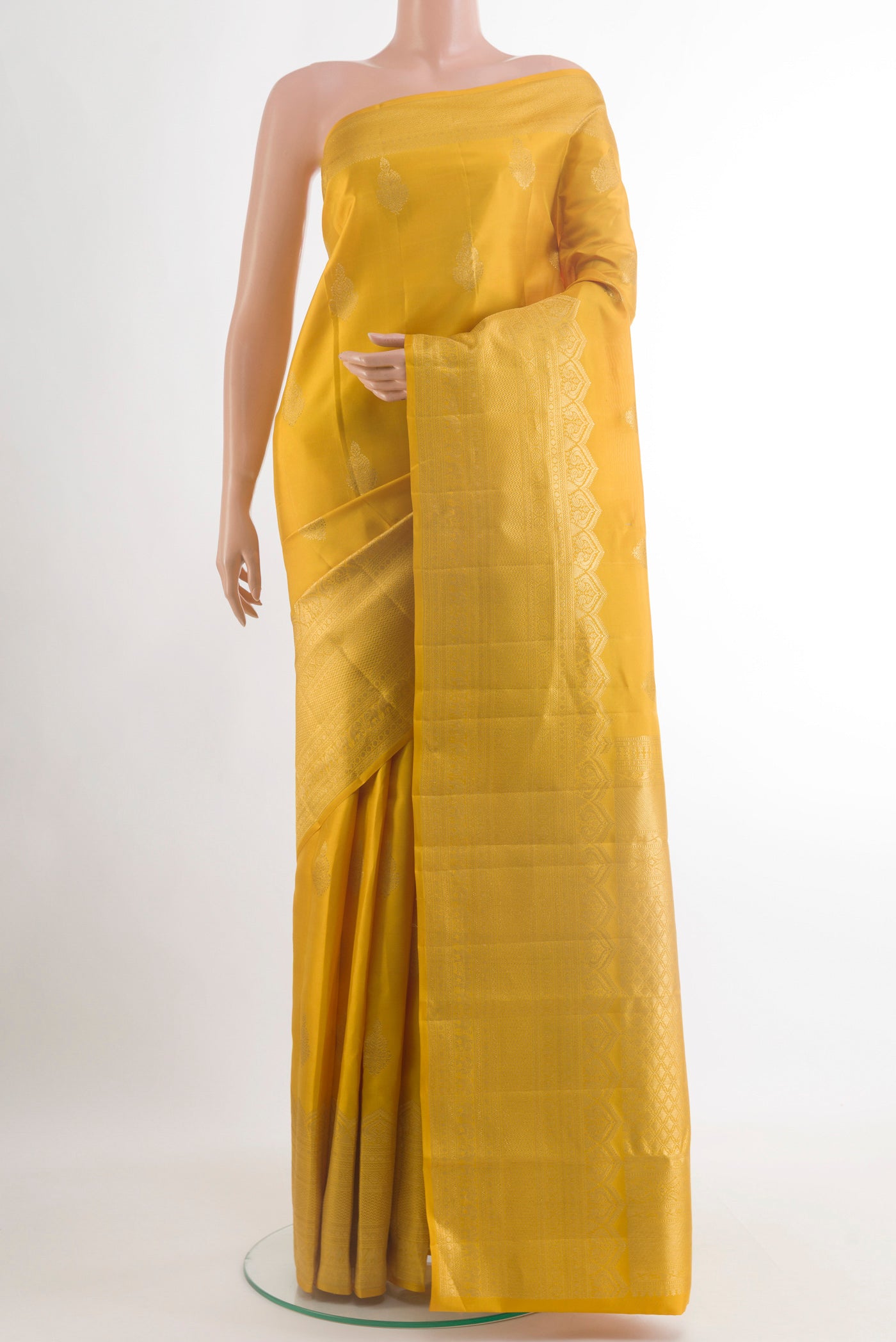 Yellow Kanchipuram Silk Saree with Zari Butta on the body and Zari Border.  displayed on a mannequin