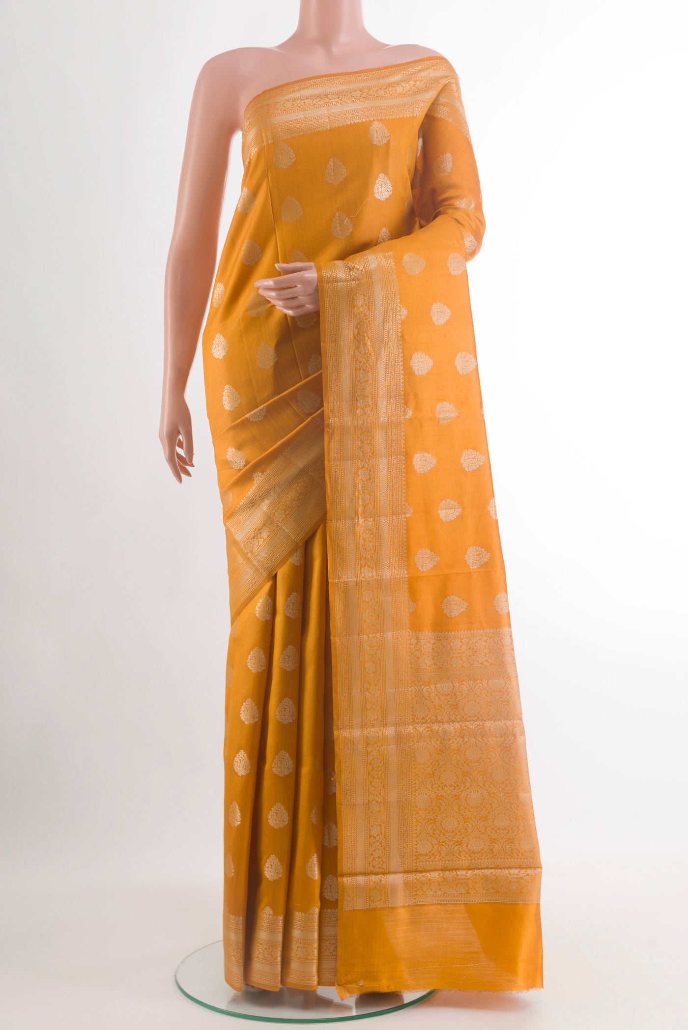 Mustard Banarasi Raw Silk Saree with Zari Butta on the body and Zari Border.  displayed on a mannequin