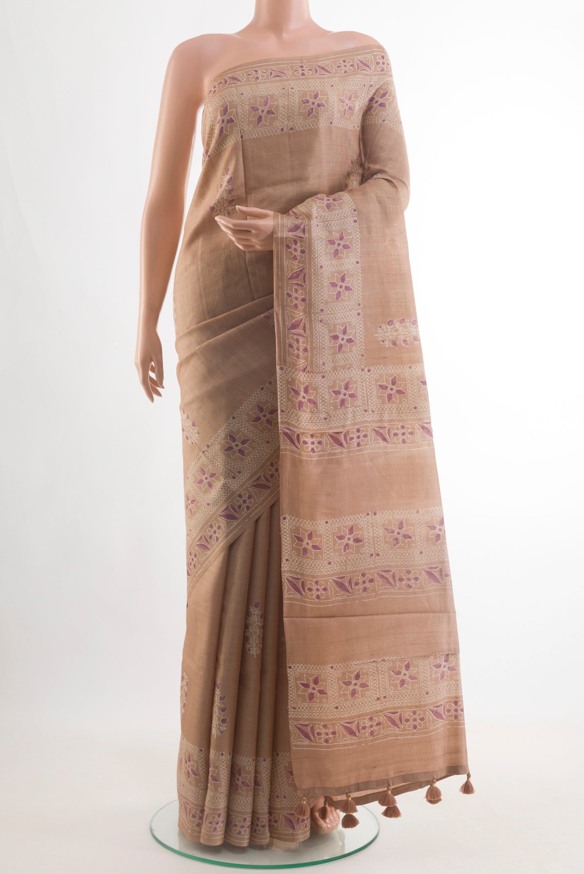 Rose Gold Tussar Saree with Printed design on the body and Zari Border.  displayed on a mannequin