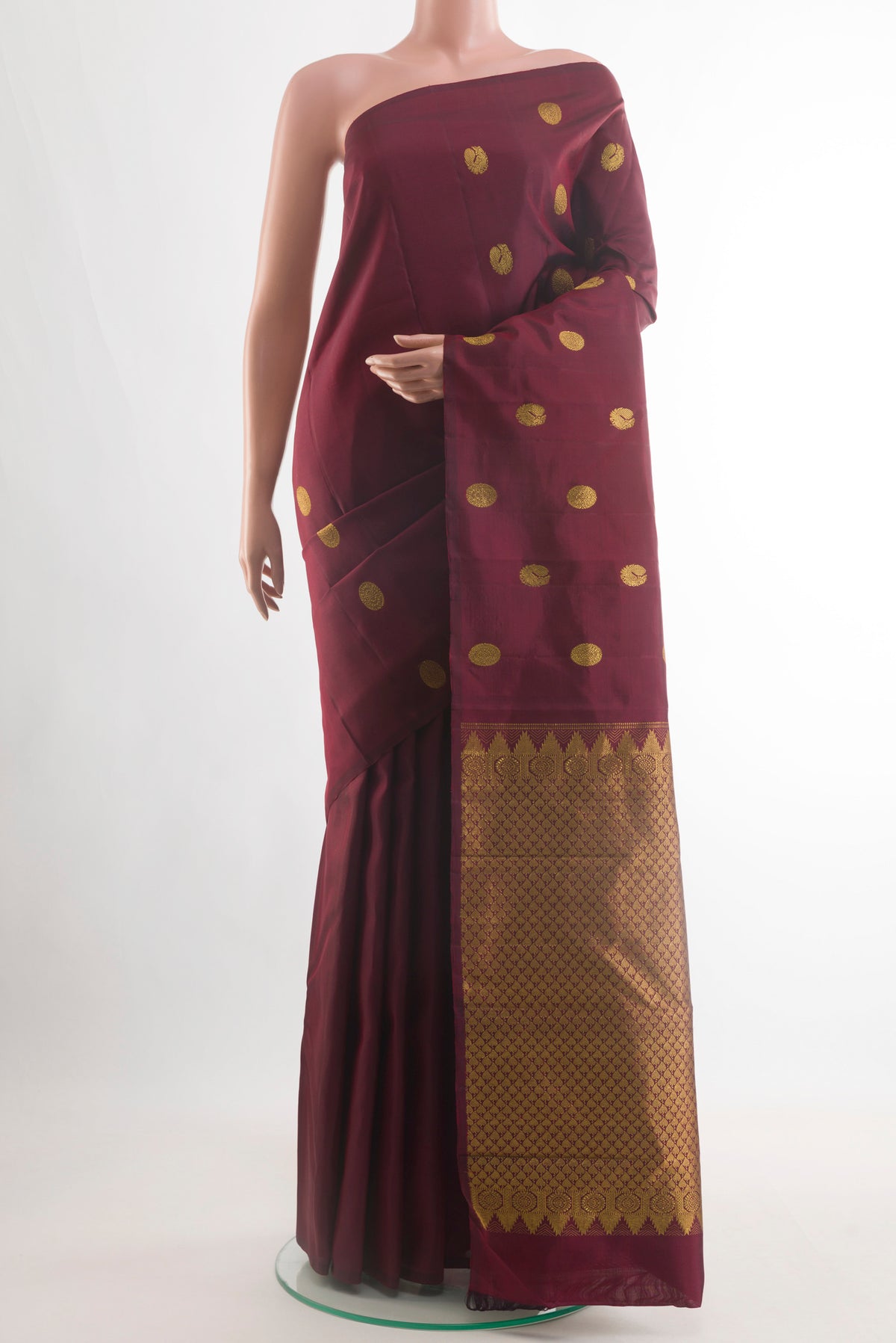 Maroon Kanchipuram Silk Saree with Zari Butta on the body and Without Border.  displayed on a mannequin