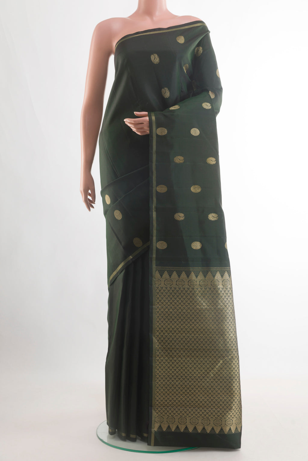 Bottle Green Kanchipuram Silk Saree with Zari Butta on the body and Zari Border.  displayed on a mannequin