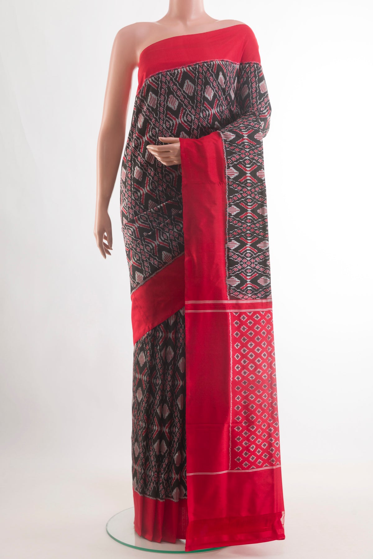 Black Pochampally Silk Saree with Pure Ikat on the body and Plain Border.  displayed on a mannequin